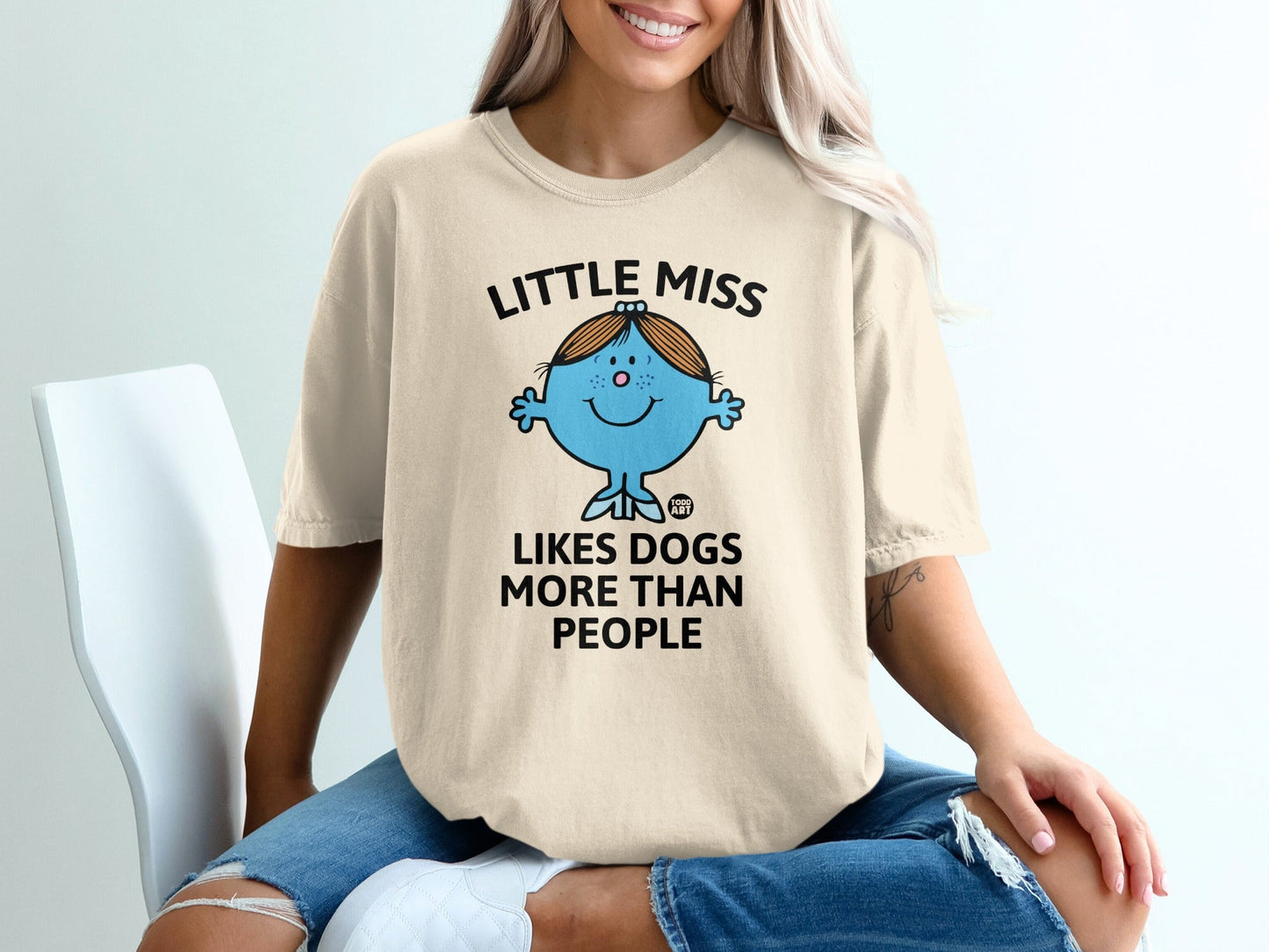 Cream t-shirt with "Little Miss Likes Dogs More Than People" and a blue cartoon dog.