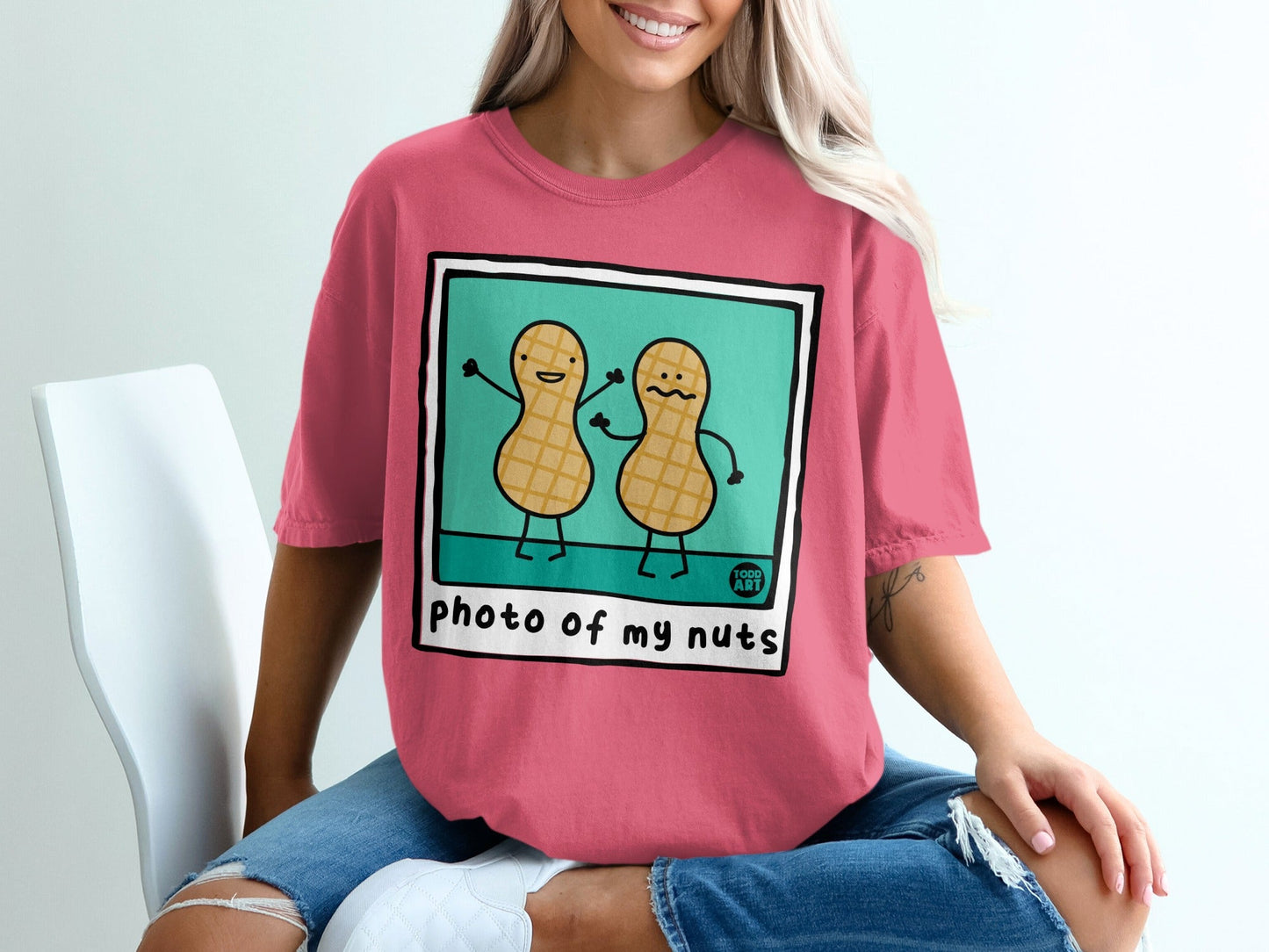 Cartoon peanuts with arms raised in greeting, printed on a pink t-shirt.