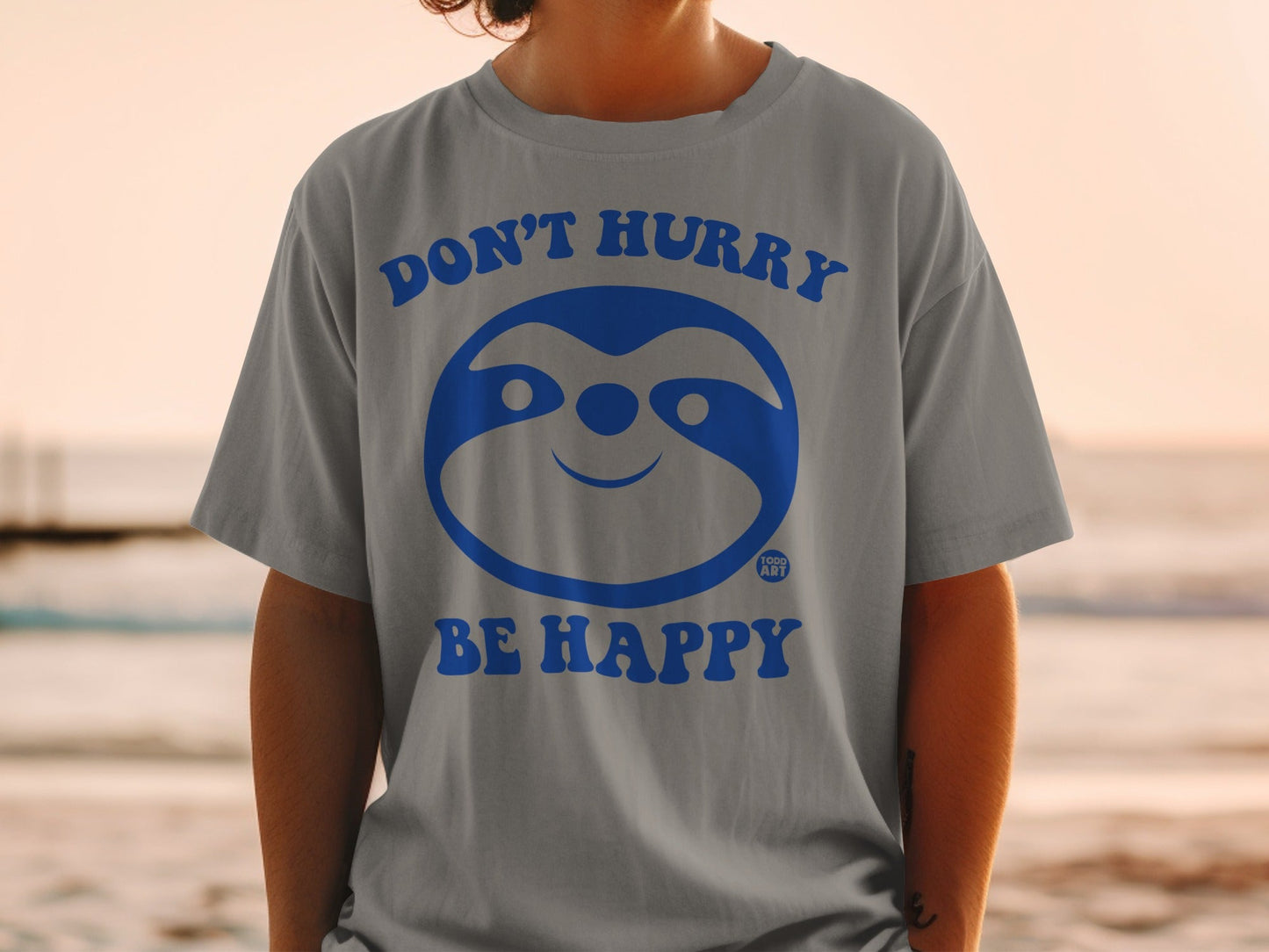 Gray t-shirt with blue sloth graphic and text "DON'T HURRY BE HAPPY".