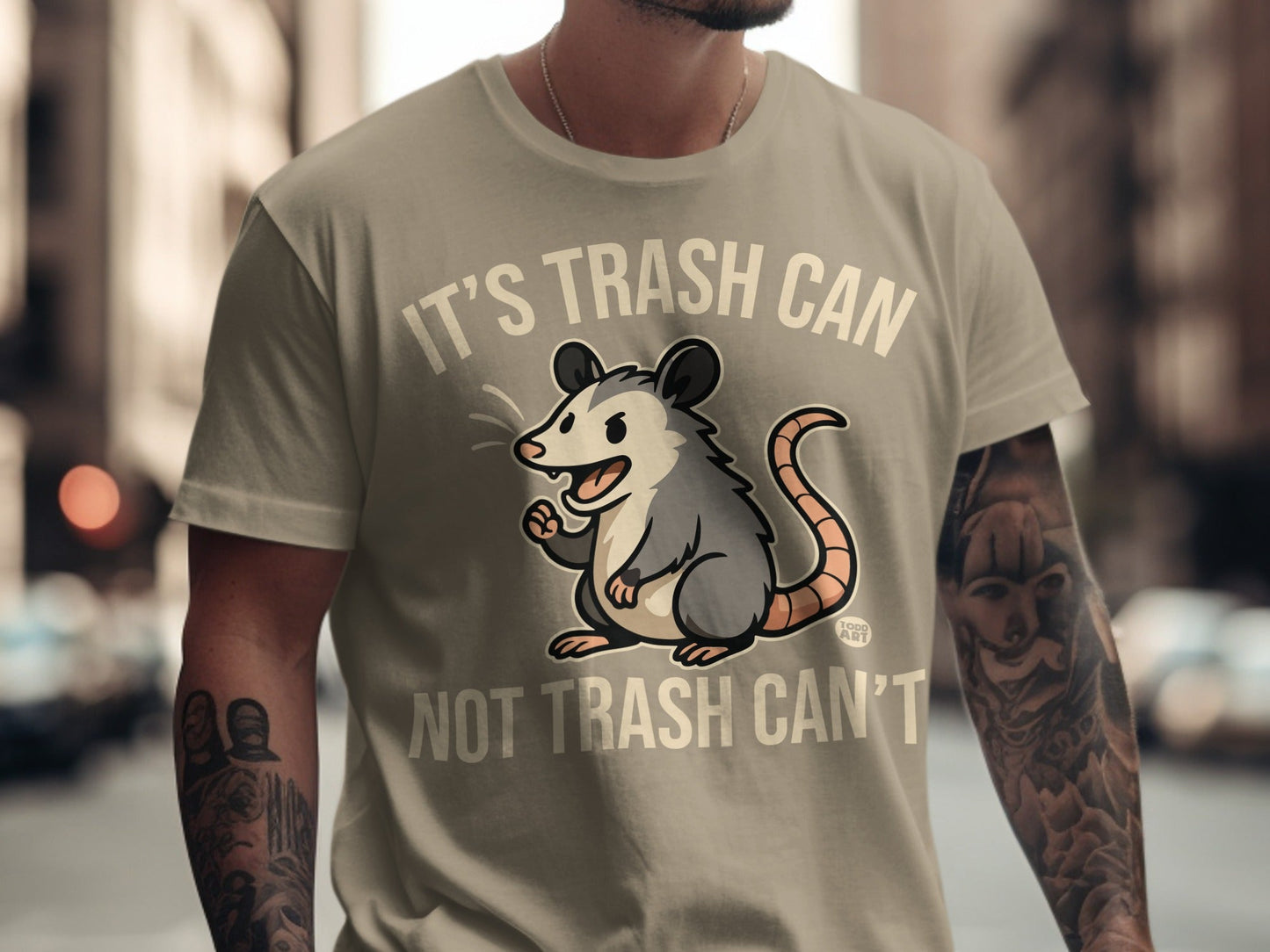 Opossum graphic on a tan t-shirt that reads "It's trash can not trash can't".