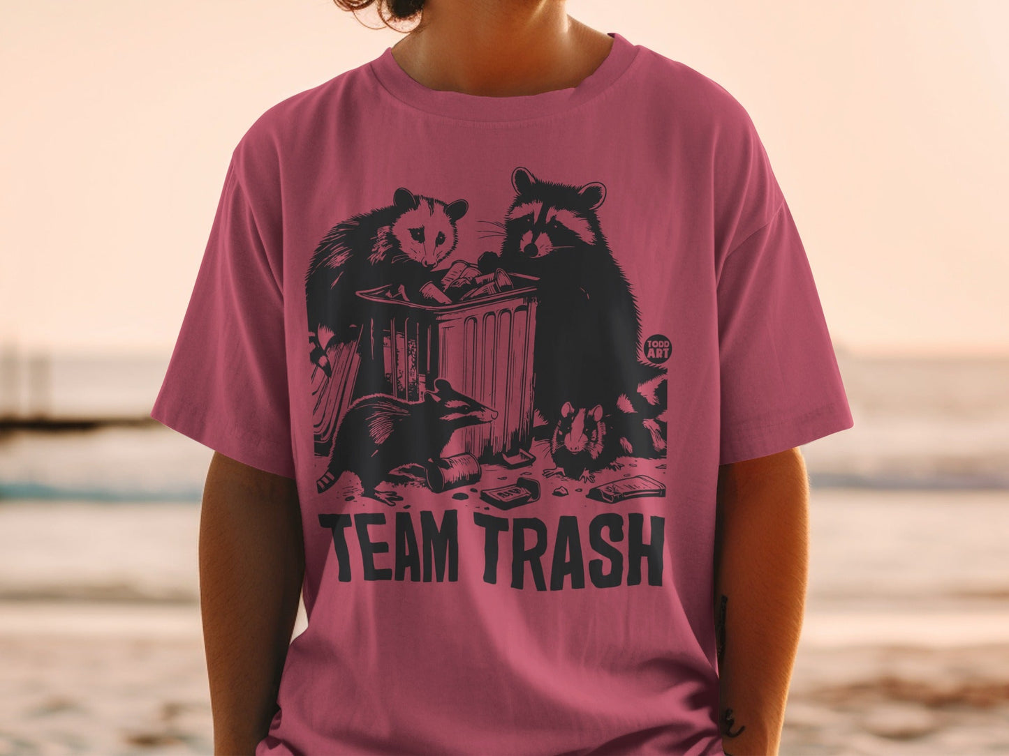 T-shirt with "TEAM TRASH" text and raccoons around a trash can.