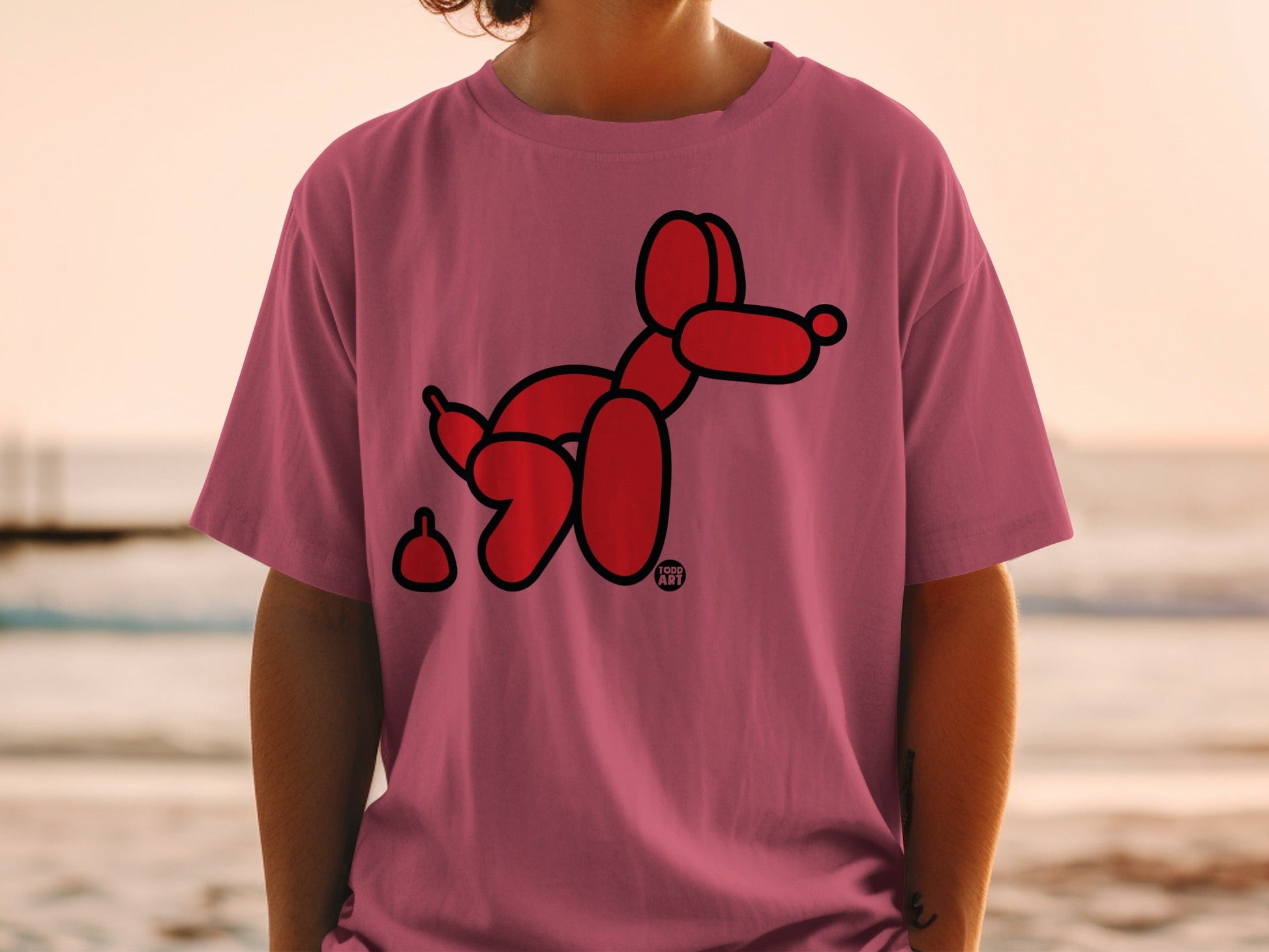 Red balloon dog and poop design on a pink t-shirt.