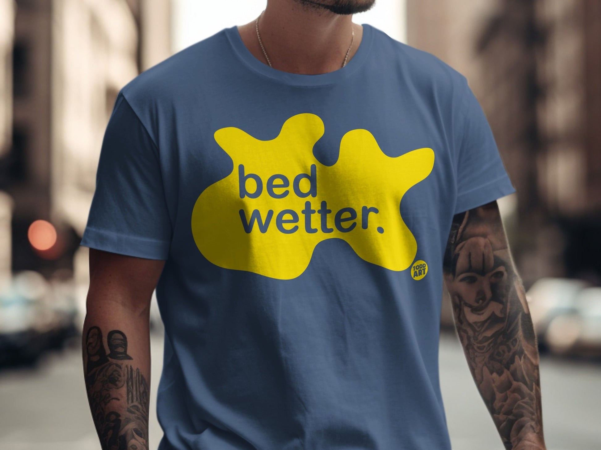 Blue t-shirt with yellow "bed wetter" text and a small "TOOD ART" logo.