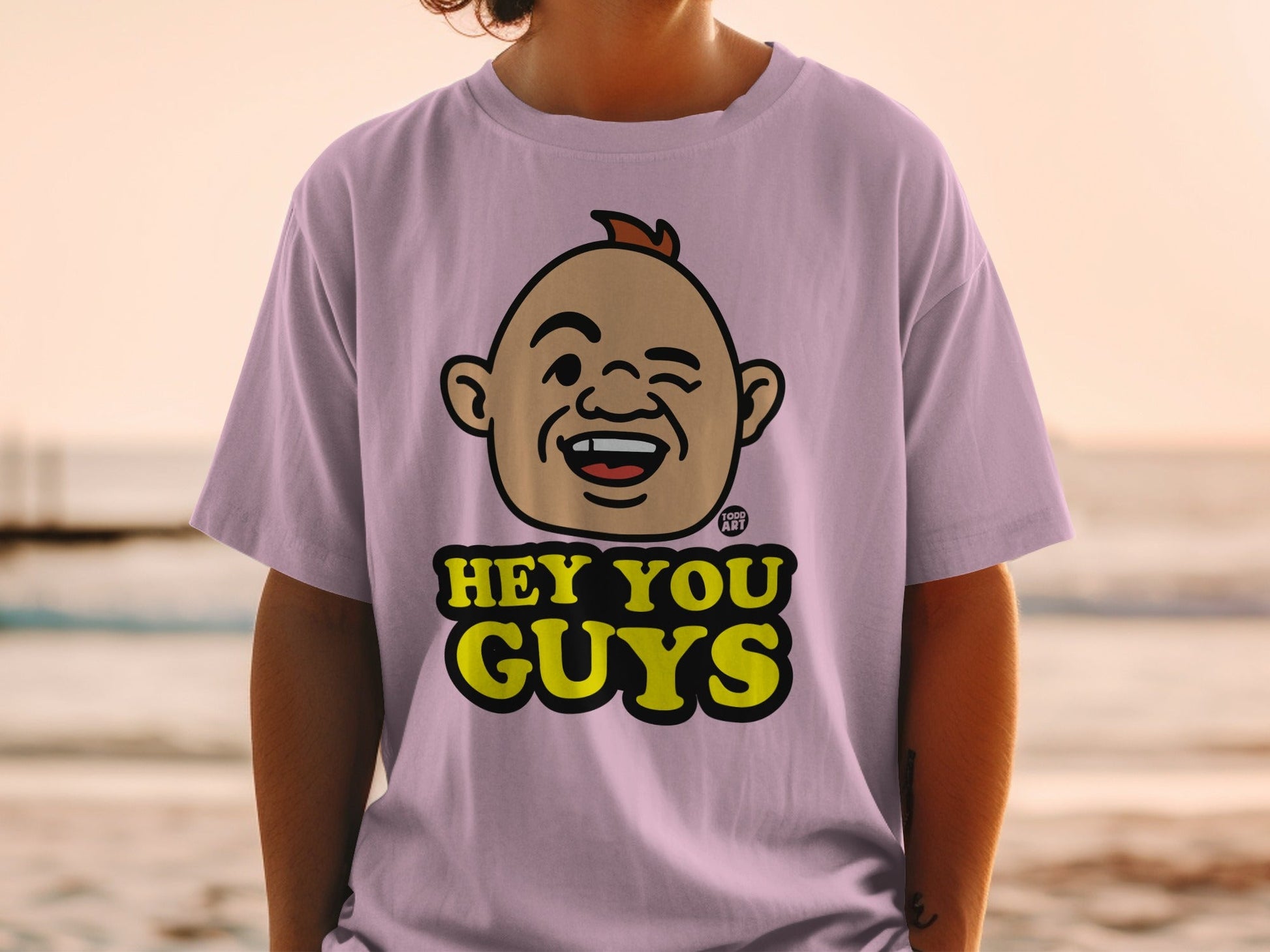 Lavender t-shirt with cartoon face and "Hey You Guys" text.