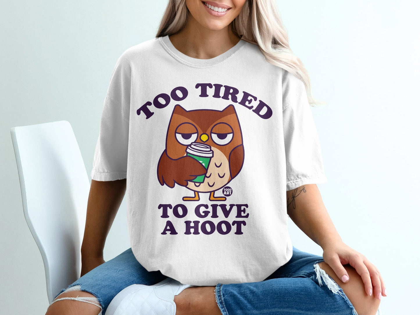 White t-shirt with cartoon owl and text "TOO TIRED TO GIVE A HOOT".