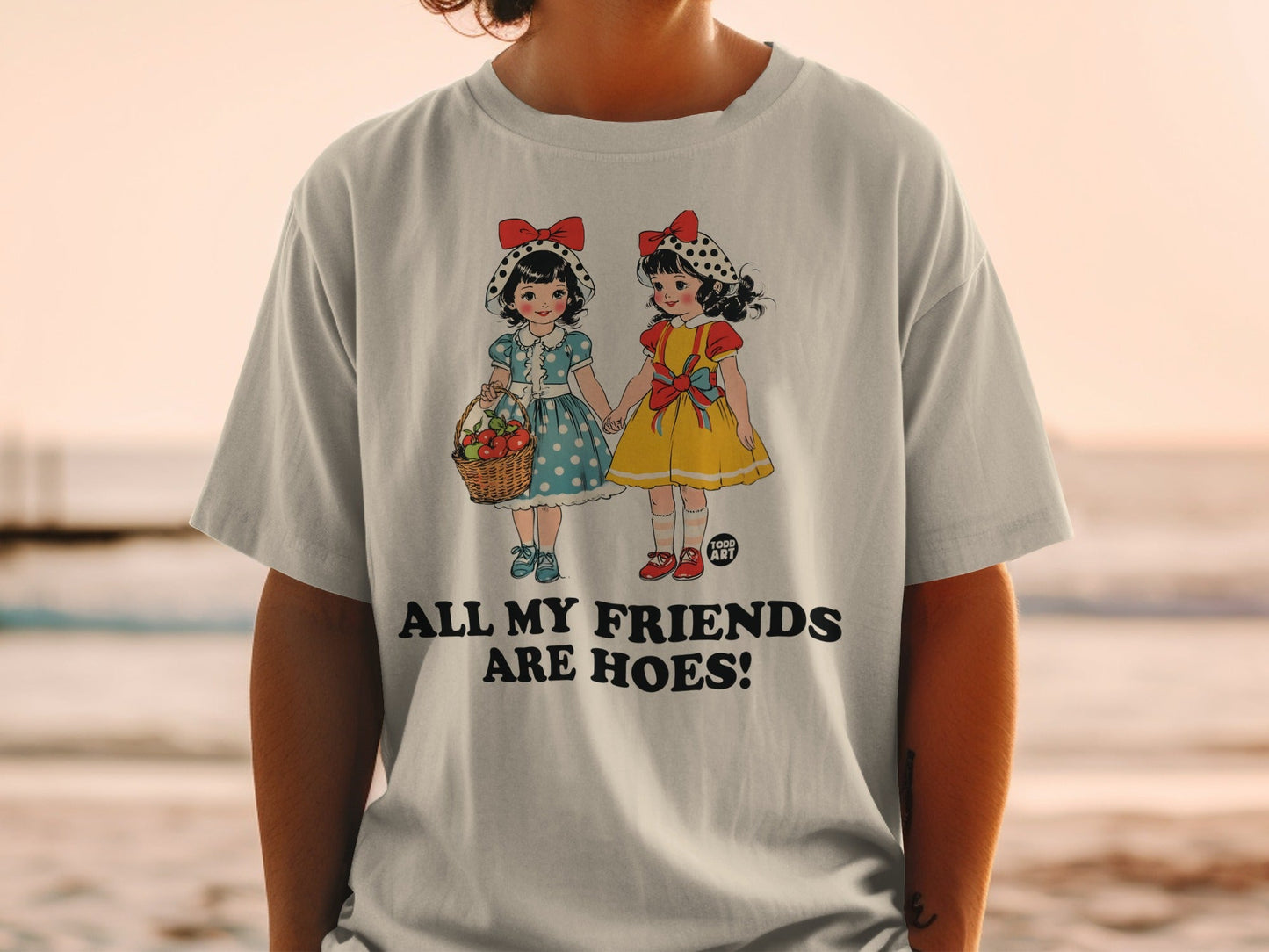 T-shirt with cartoon girls holding hands, basket of flowers, text "ALL MY FRIENDS ARE HOES!"