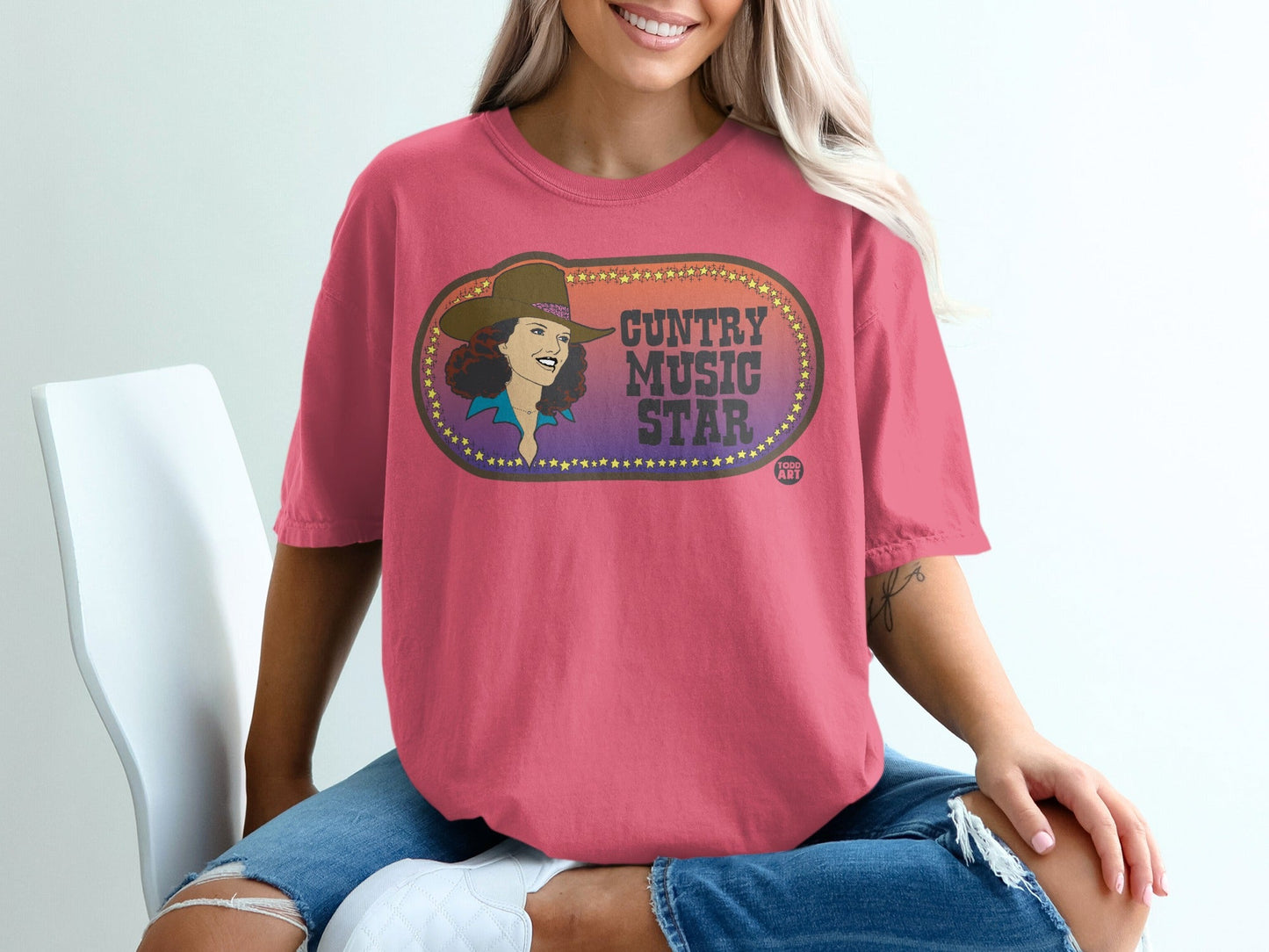Pink t-shirt featuring "Country Music Star" oval logo with a woman's silhouette.