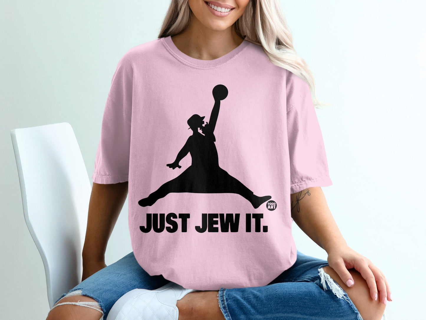 Woman in pink t-shirt with black silhouette of a person jumping to dunk a basketball.