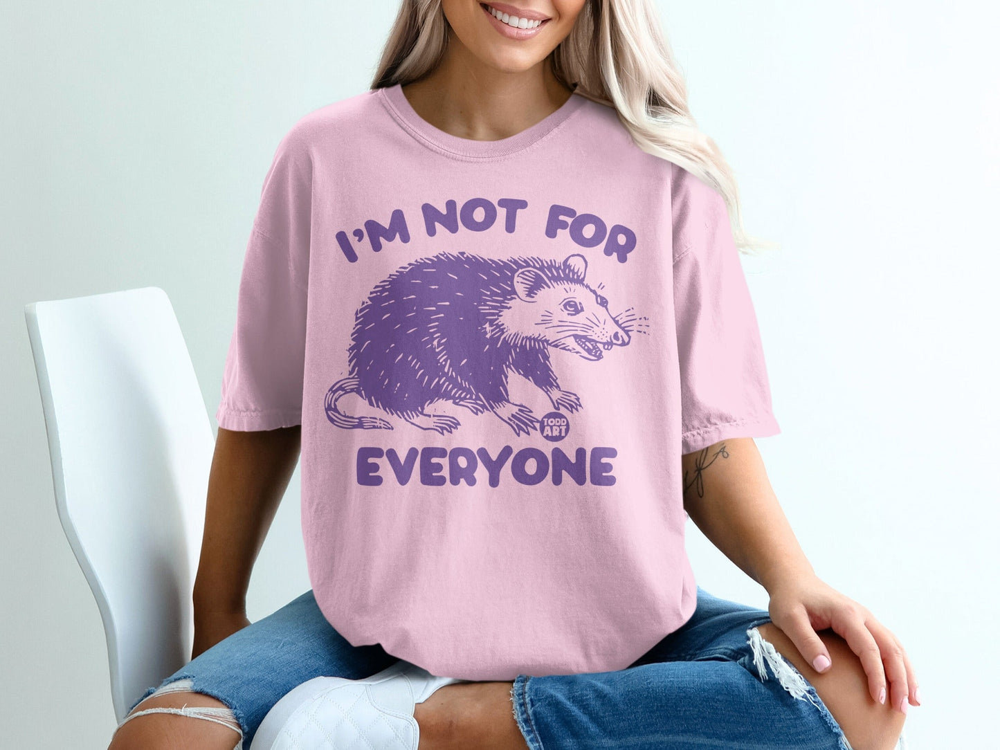 Pink t-shirt with purple opossum graphic and "I'm not for everyone" text.