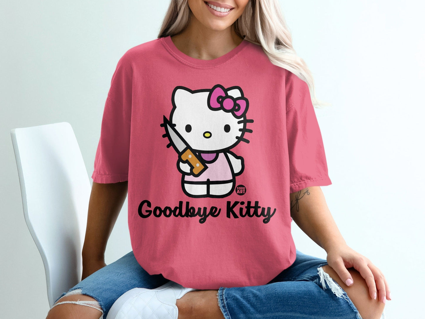 Pink t-shirt with Hello Kitty holding a knife, text says "Goodbye Kitty."