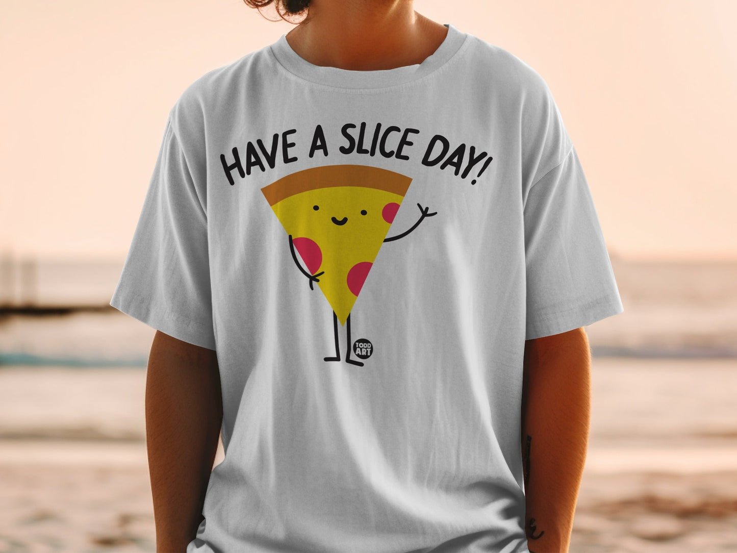 White t-shirt with a smiling pizza slice character saying "HAVE A SLICE DAY!".