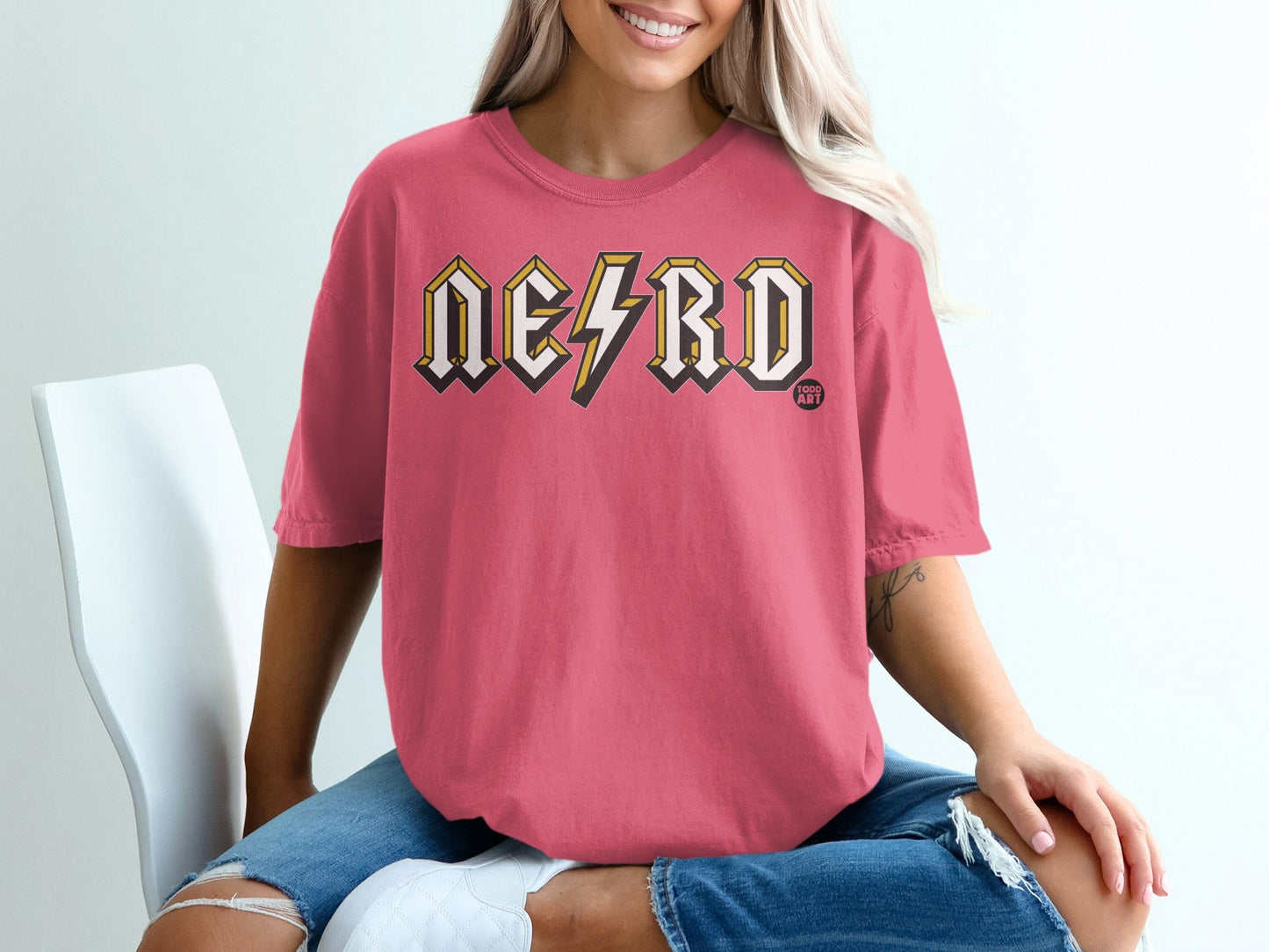 Pink t-shirt with "NERD" in yellow lightning bolt font, small "FOCO ART" logo.