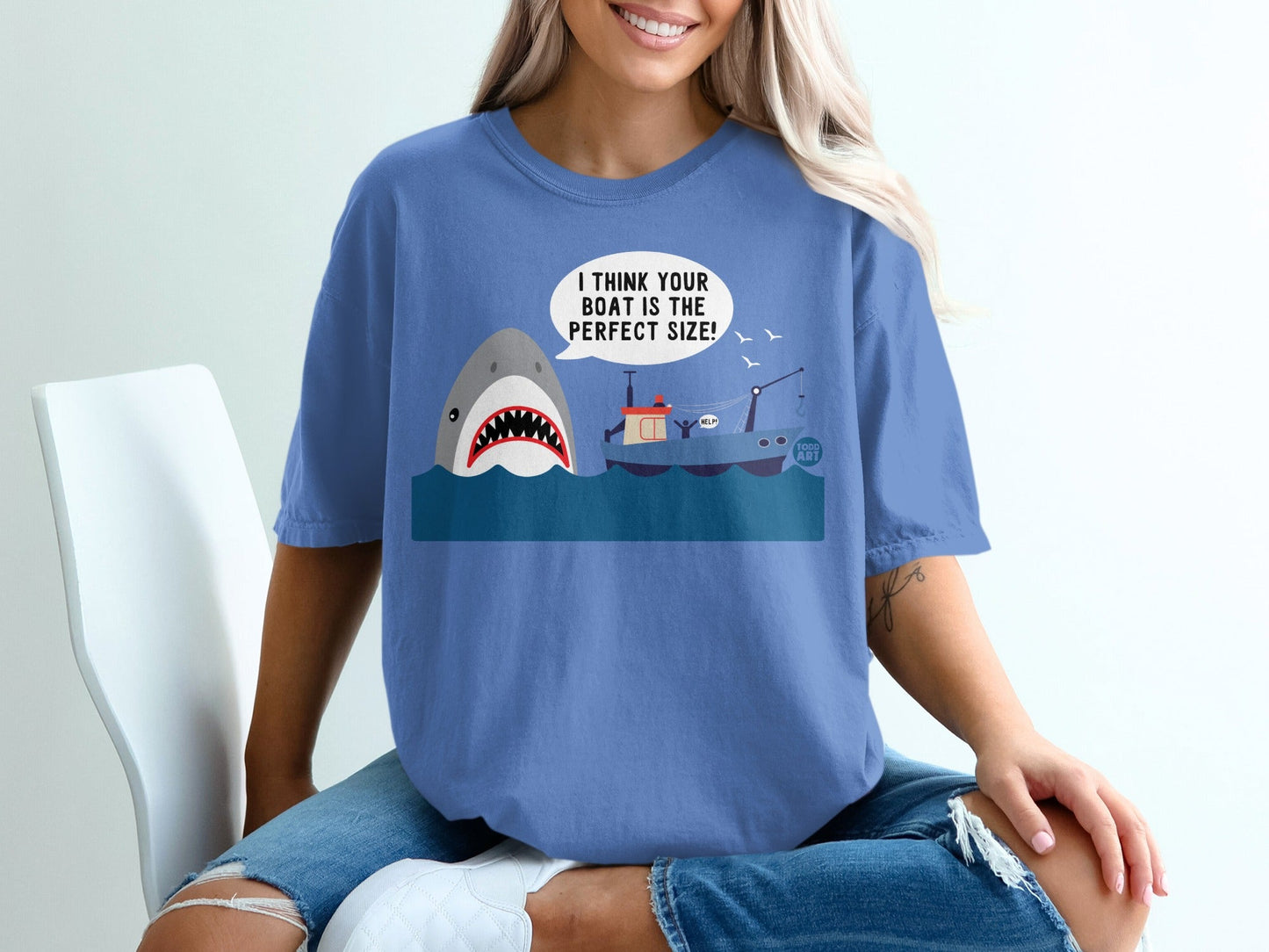 Blue t-shirt with shark and boat graphic that says "I THINK YOUR BOAT IS THE PERFECT SIZE!"