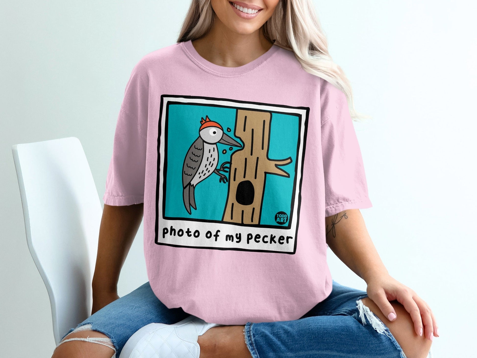 Pink t-shirt with cartoon woodpecker on tree and text "photo of my pecker".