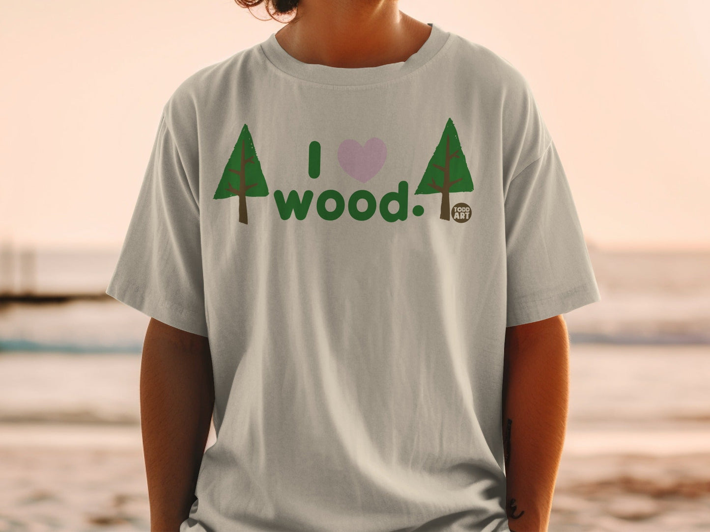 T-shirt with "I love wood." text, pink heart, and two evergreen trees.