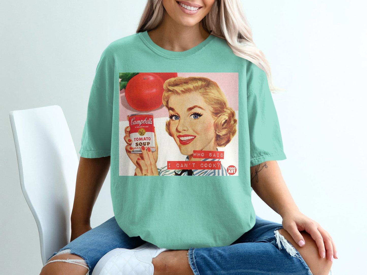 Woman holding Campbell's tomato soup can with "Who said I can't cook?"