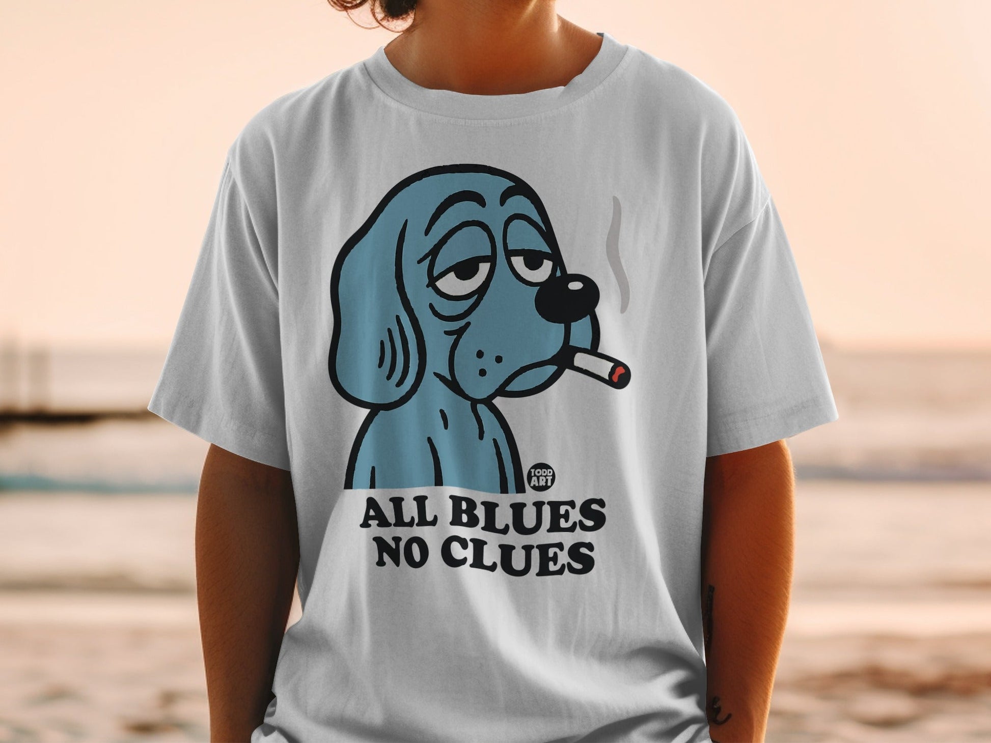Blue cartoon dog wearing a shirt that says "ALL BLUES NO CLUES".