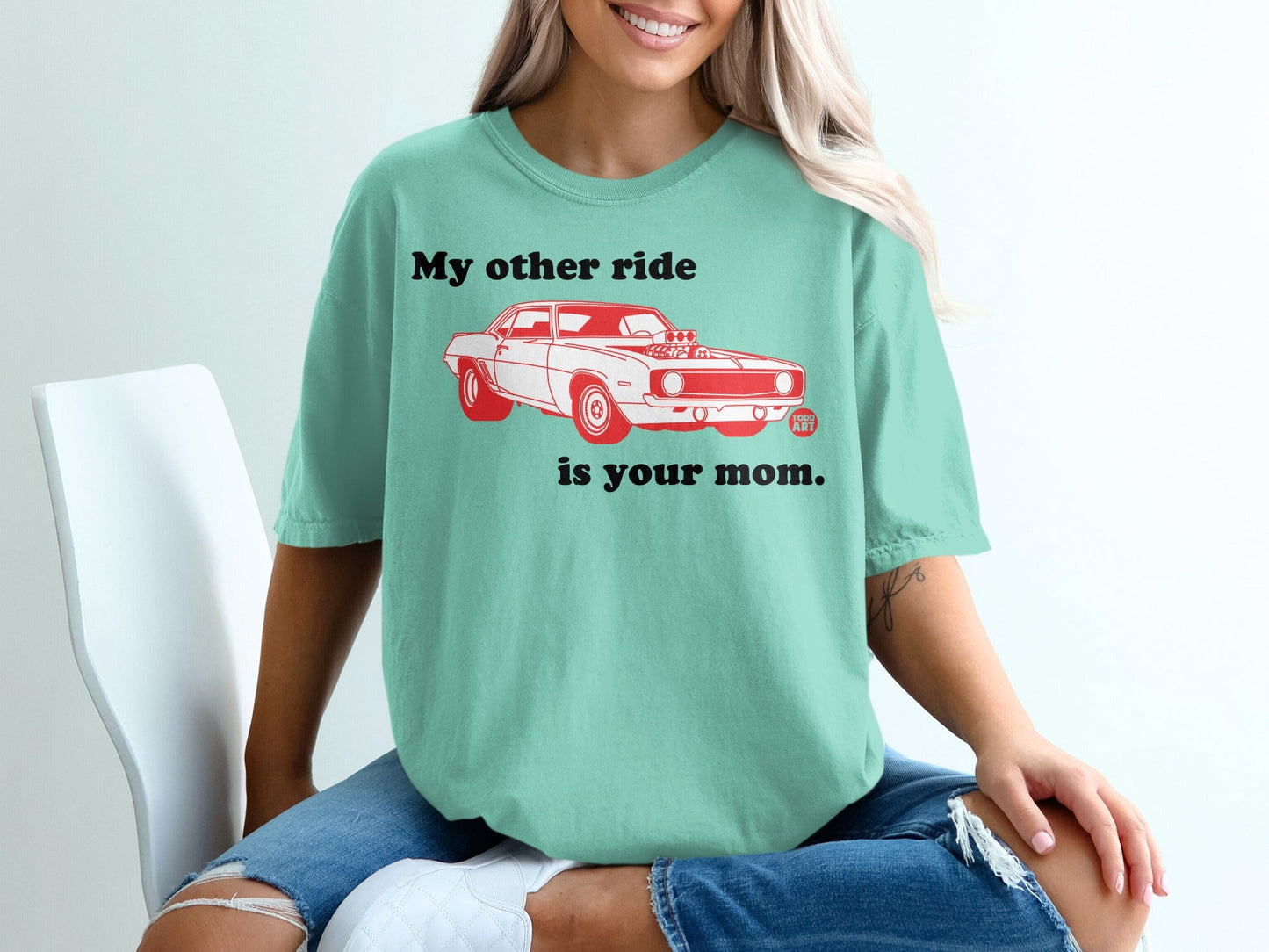 Teal t-shirt with red text and a graphic of a vintage car.