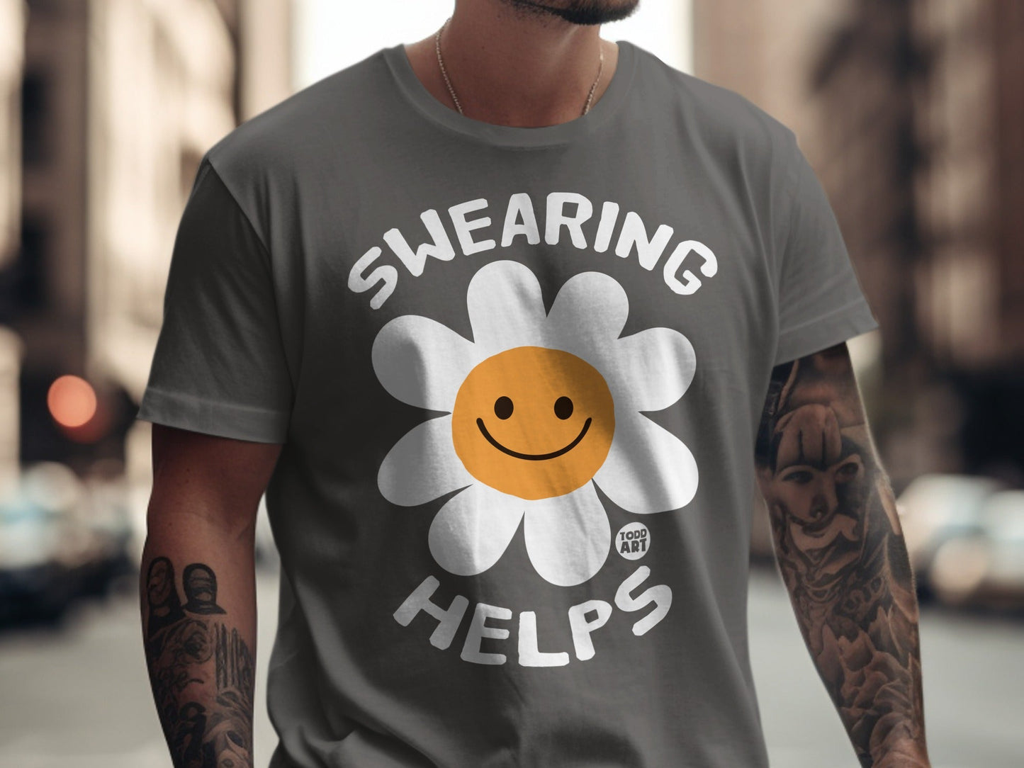 Gray t-shirt with "SWEARING HELPS" and a smiling daisy graphic.