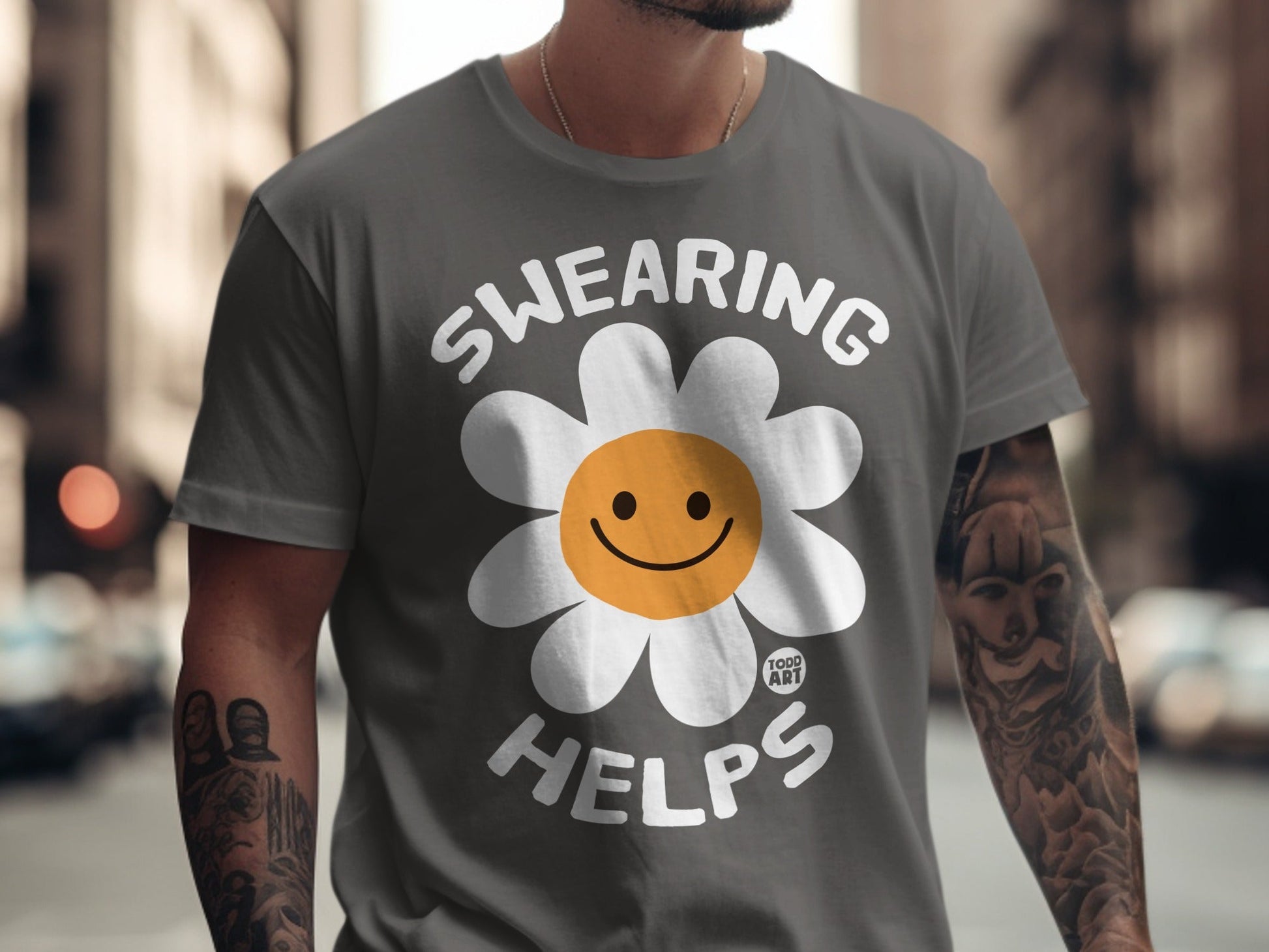 Gray t-shirt with "SWEARING HELPS" and a smiling daisy graphic.