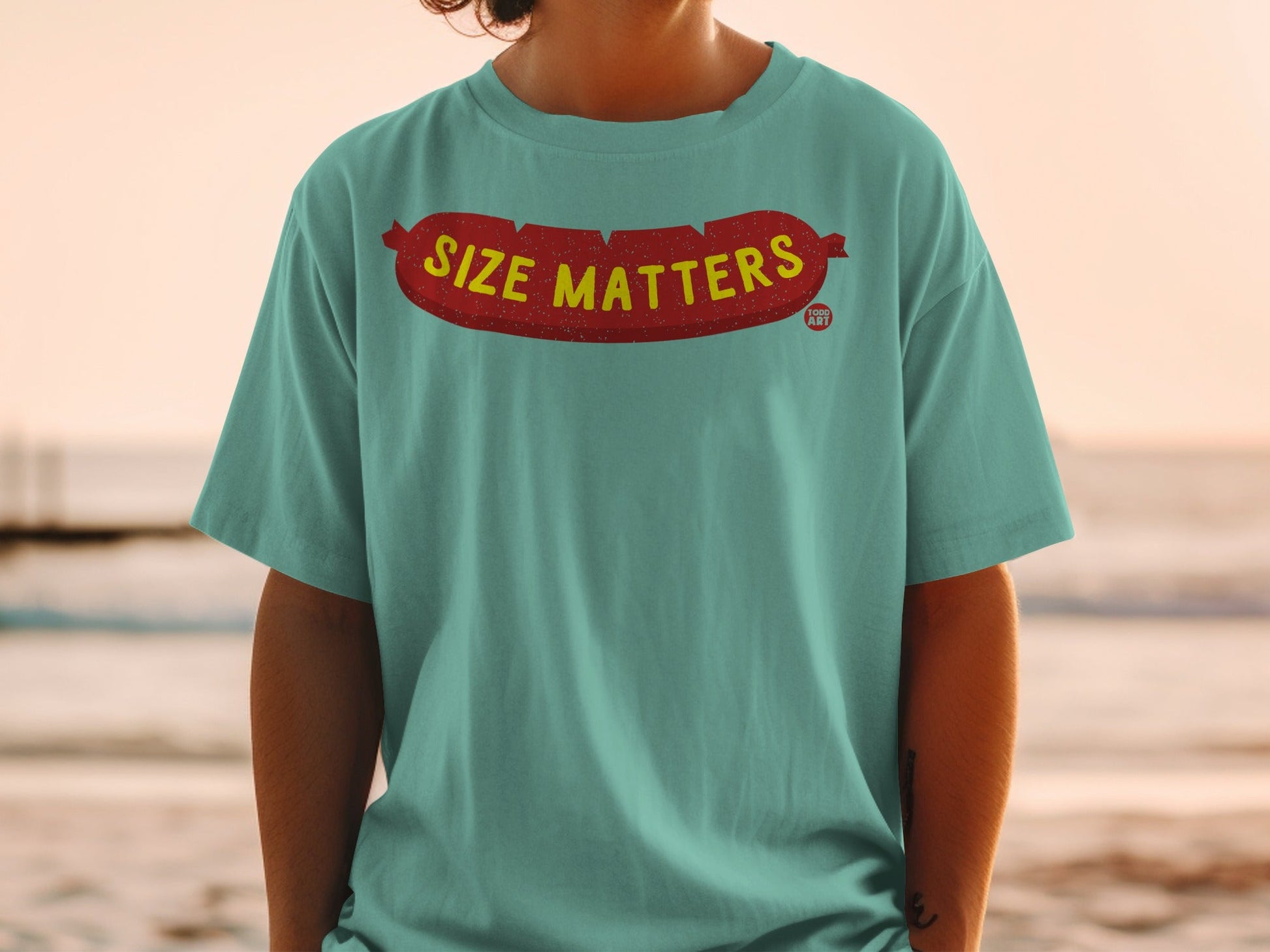 Teal t-shirt with red sausage graphic and "SIZE MATTERS" text.