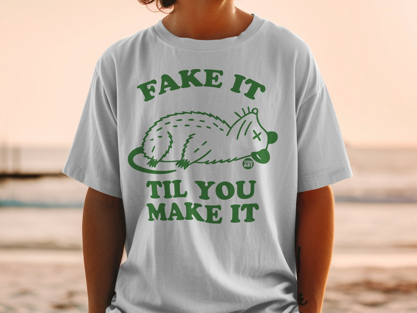 T-shirt with "Fake It Til You Make It" and possum graphic.