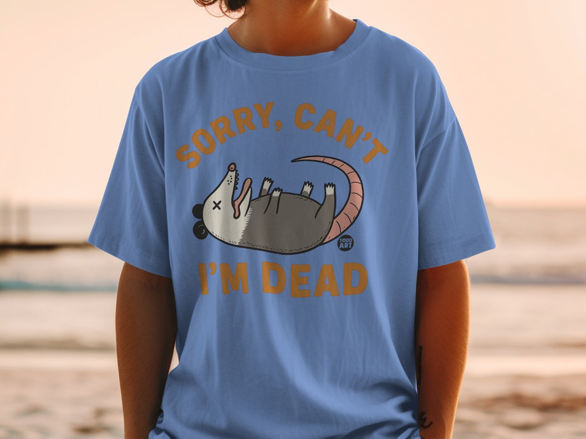Blue t-shirt with cartoon possum and text "SORRY, CAN'T I'M DEAD".
