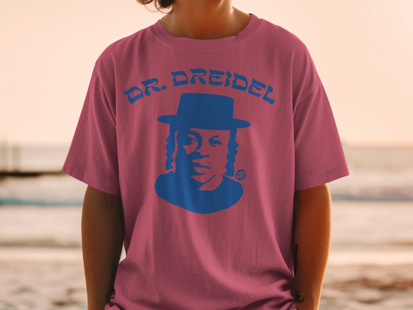Dr. Dreidel graphic t-shirt with blue hat and face illustration.