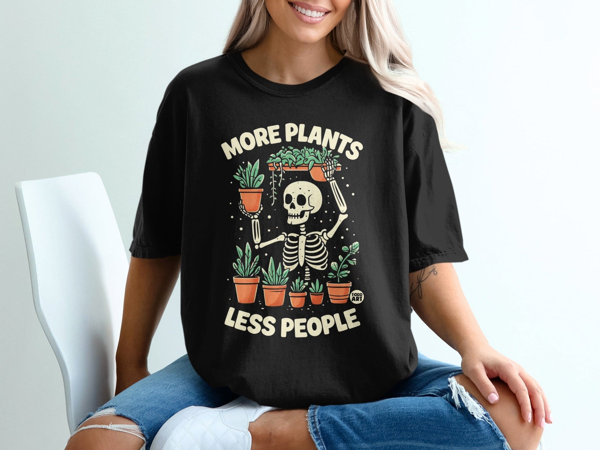 Black t-shirt with skeleton holding potted plants and text "More Plants Less People."