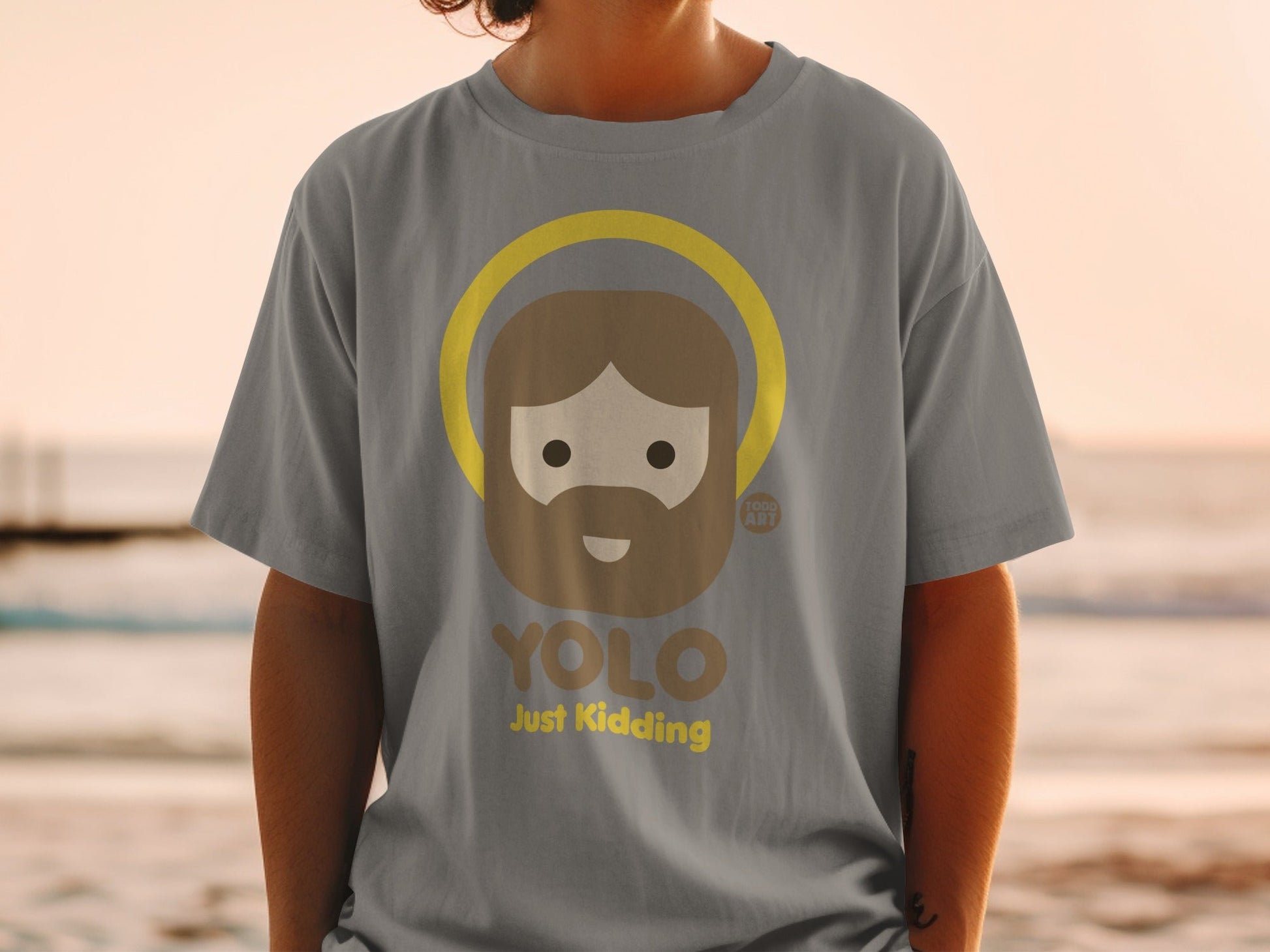 Gray t-shirt with "YOLO Just Kidding" and cartoon Jesus graphic.