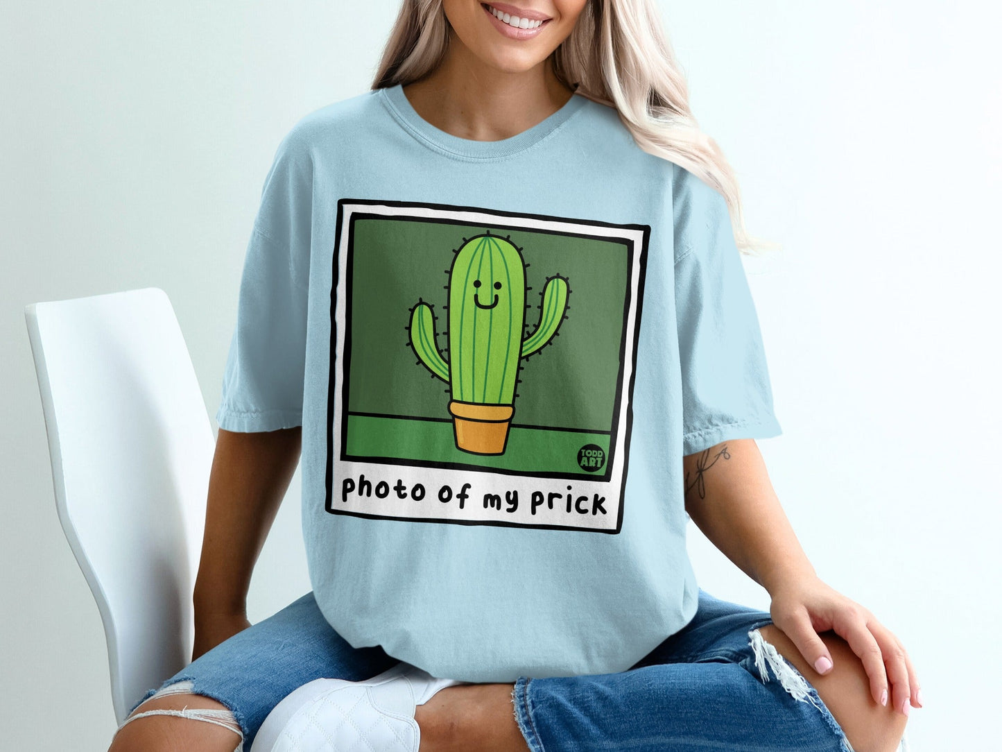 Light blue t-shirt with a cartoon cactus graphic and text "photo of my prick".