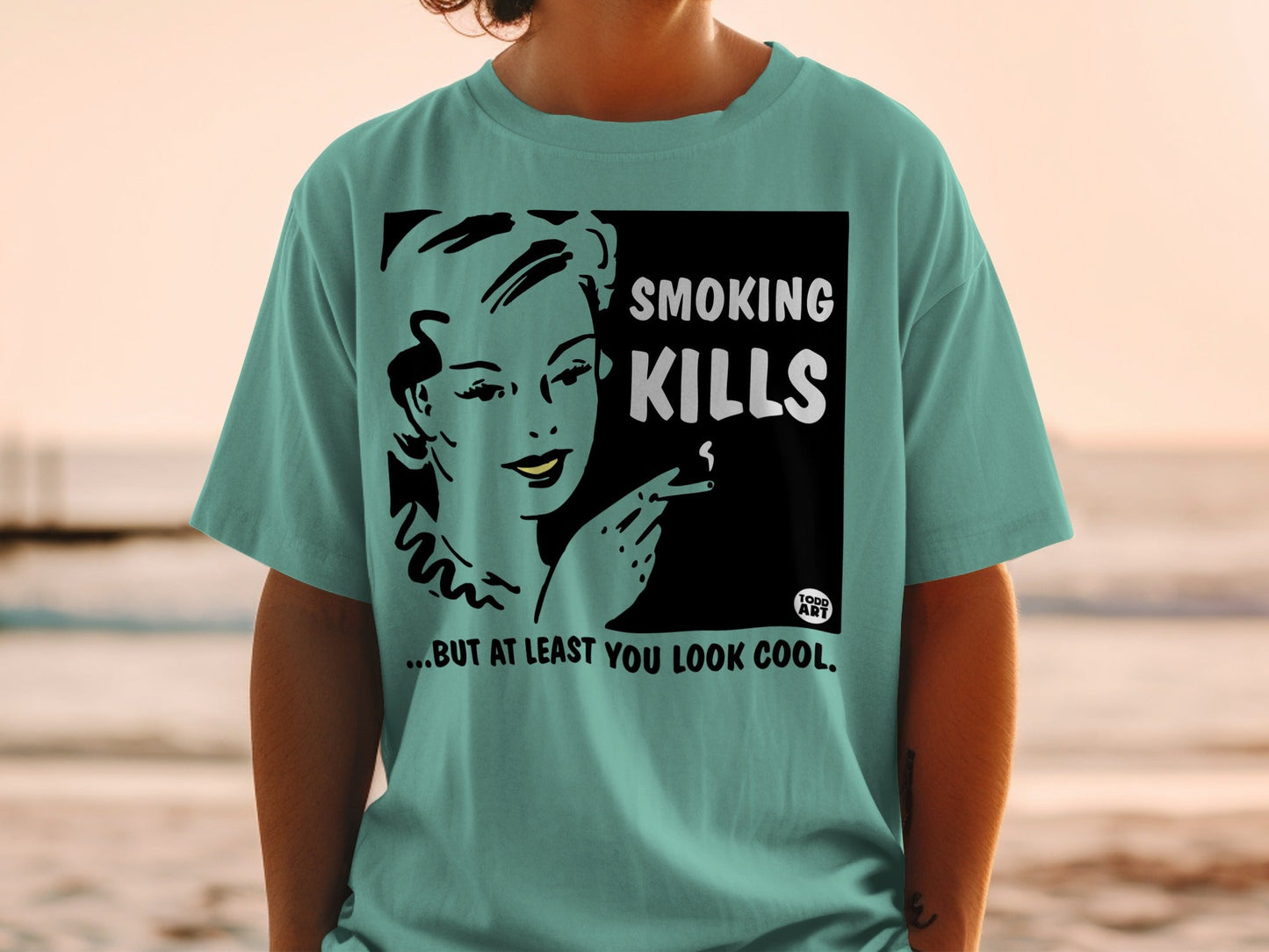 T-shirt with "Smoking Kills... But at Least You Look Cool" text and vintage woman smoking illustration.