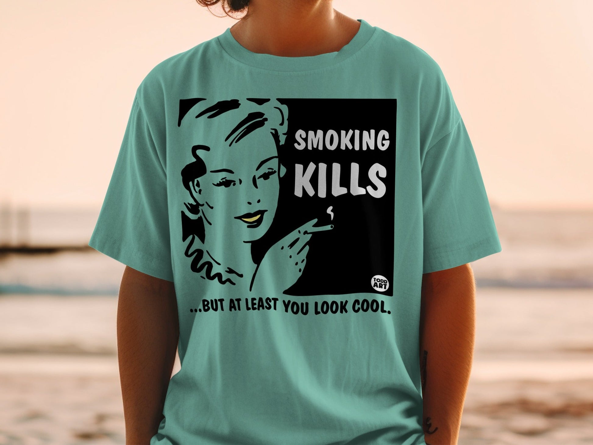 T-shirt with "Smoking Kills... But at Least You Look Cool" text and vintage woman smoking illustration.