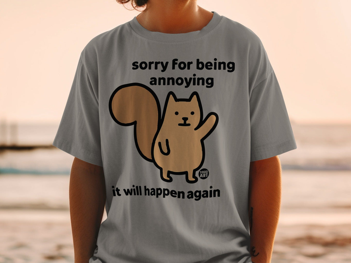 Grey t-shirt with a cartoon squirrel and text "sorry for being annoying it will happen again".