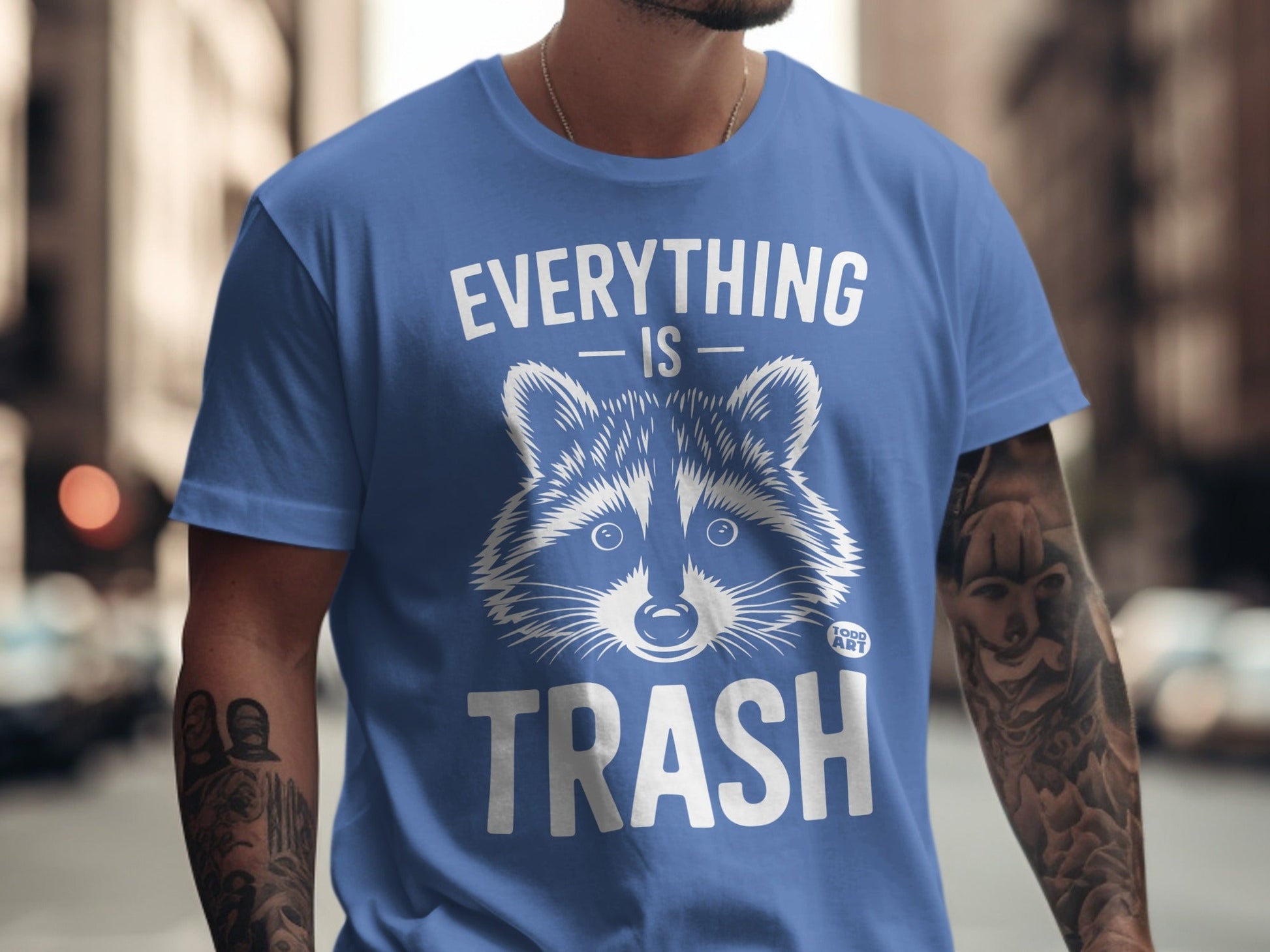 Blue t-shirt with raccoon graphic and "EVERYTHING IS TRASH" text.