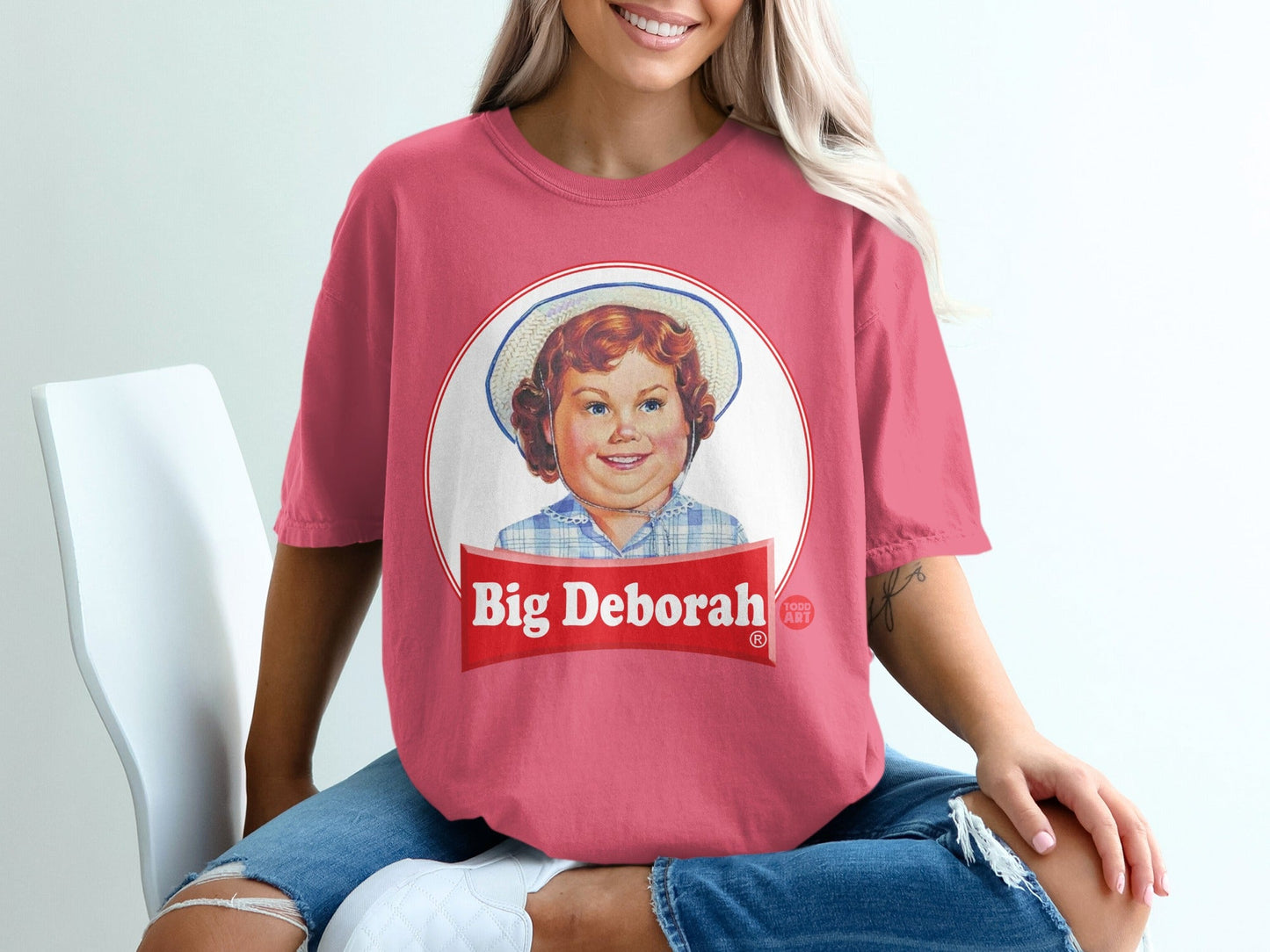 Pink t-shirt with circular graphic of a smiling child and "Big Deborah" text.