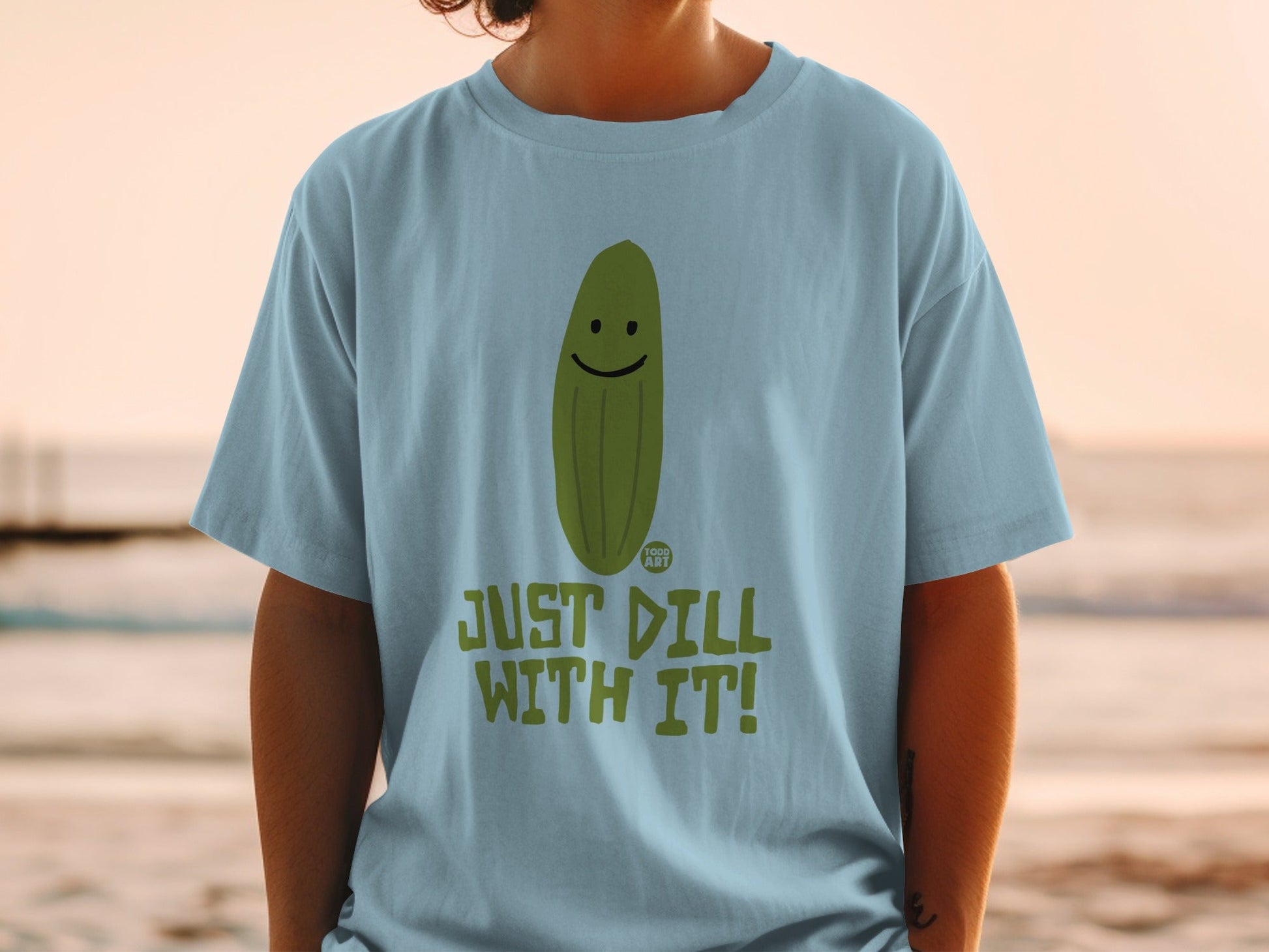 Light blue t-shirt with a smiling pickle and "JUST DILL WITH IT!" text.