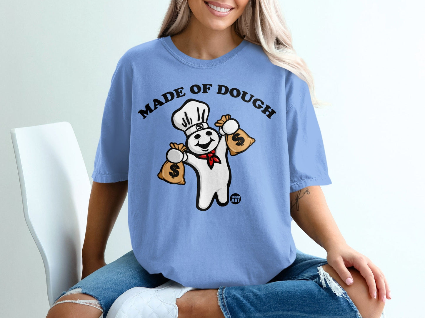 Pillsbury Doughboy wearing chef hat holding money bags, "Made of Dough" text.