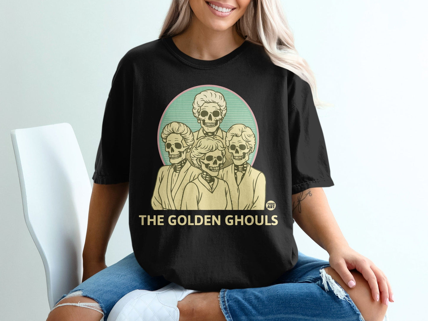 Black t-shirt with four skeletons in circle, "THE GOLDEN GHOULS" text.