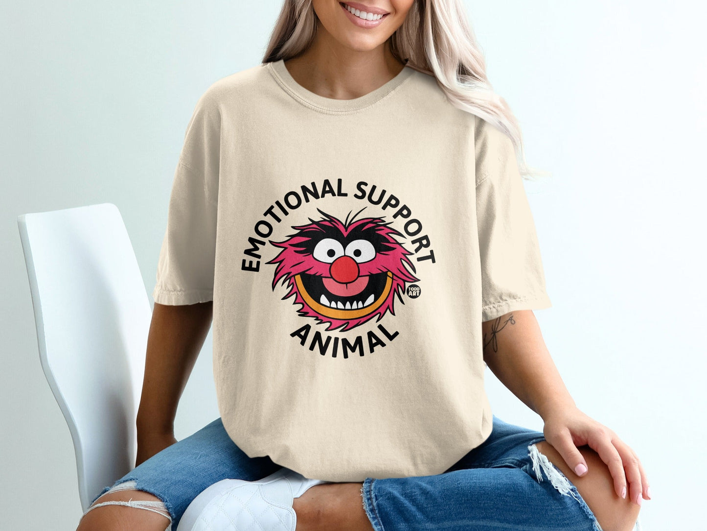 Beige t-shirt with "Emotional Support Animal" text and Muppet Animal cartoon graphic.