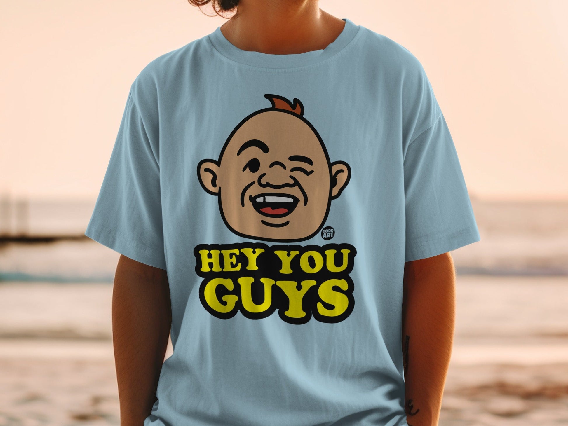 Light blue t-shirt with cartoon character and "HEY YOU GUYS" text.
