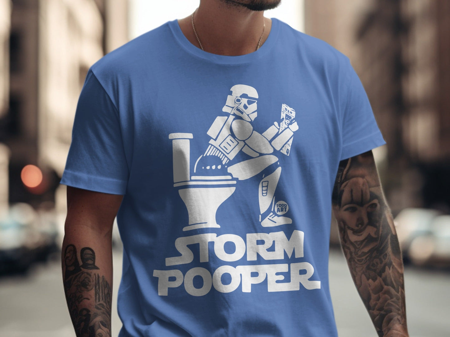 Stormtrooper sitting on a toilet, reading, on a blue t-shirt.