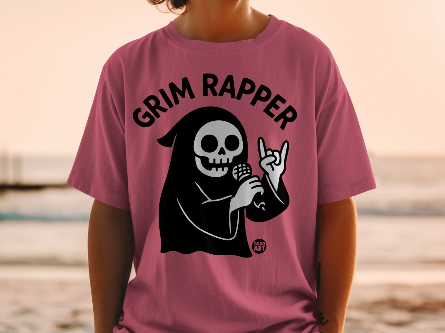 Grim Reaper wearing pink t-shirt, holding microphone, with "Grim Rapper" text.