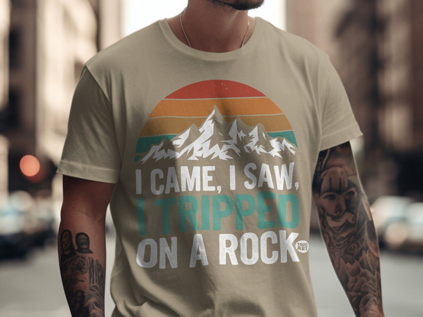 T-shirt with mountain sunset graphic and text "I came, I saw, I tripped on a rock."