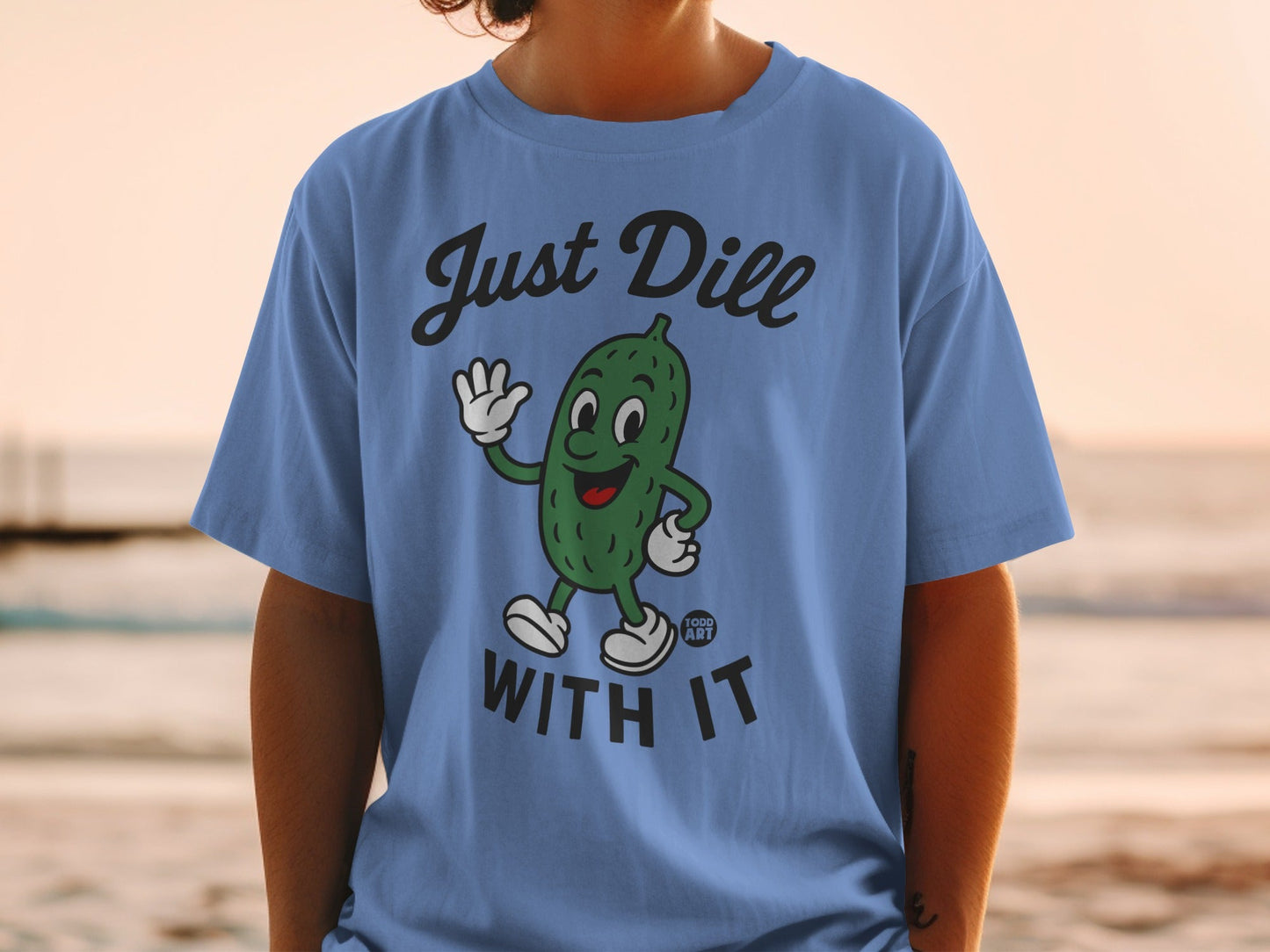 Blue t-shirt with cartoon pickle saying "Just Dill With It."