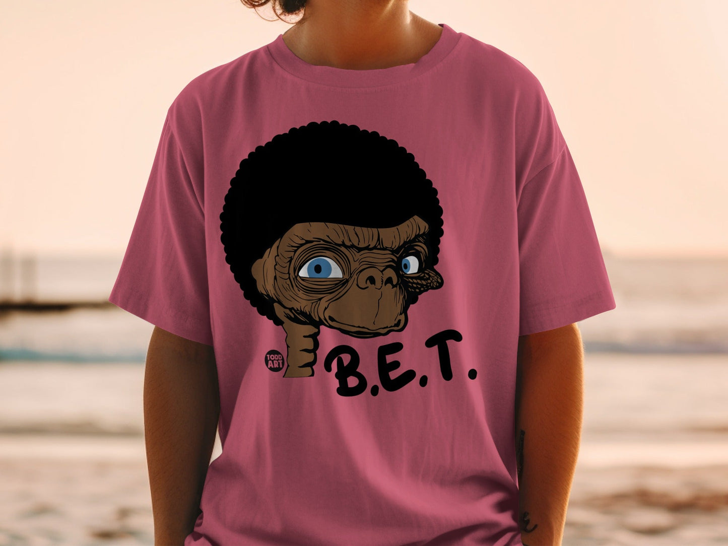 T-shirt featuring E.T. character with large blue eyes and "B.E.T." text.
