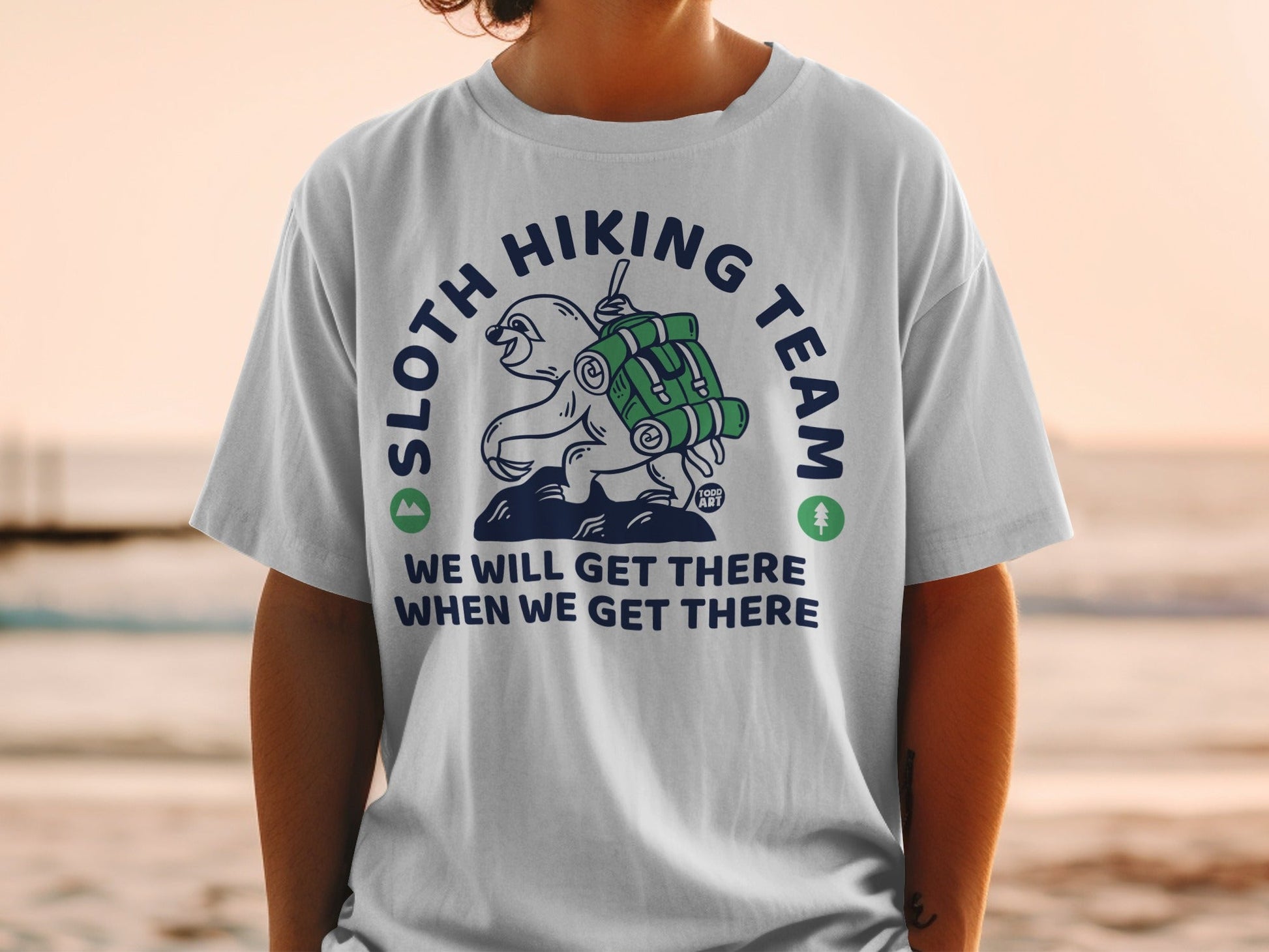 T-shirt with sloth hiking graphic and text "SLOTH HIKING TEAM WE WILL GET THERE WHEN WE GET THERE".