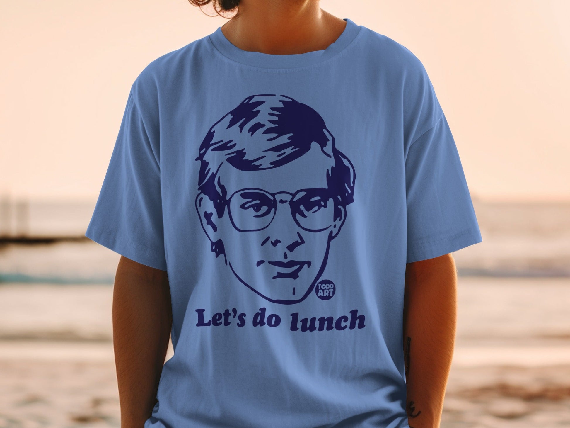 Blue t-shirt with a portrait and the text "Let's do lunch".