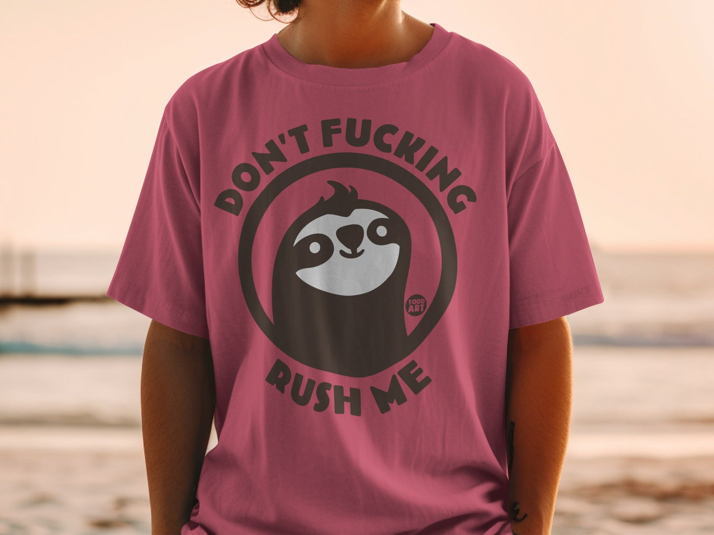 Sloth wearing sunglasses on pink t-shirt, "Don't Fucking Rush Me" text.