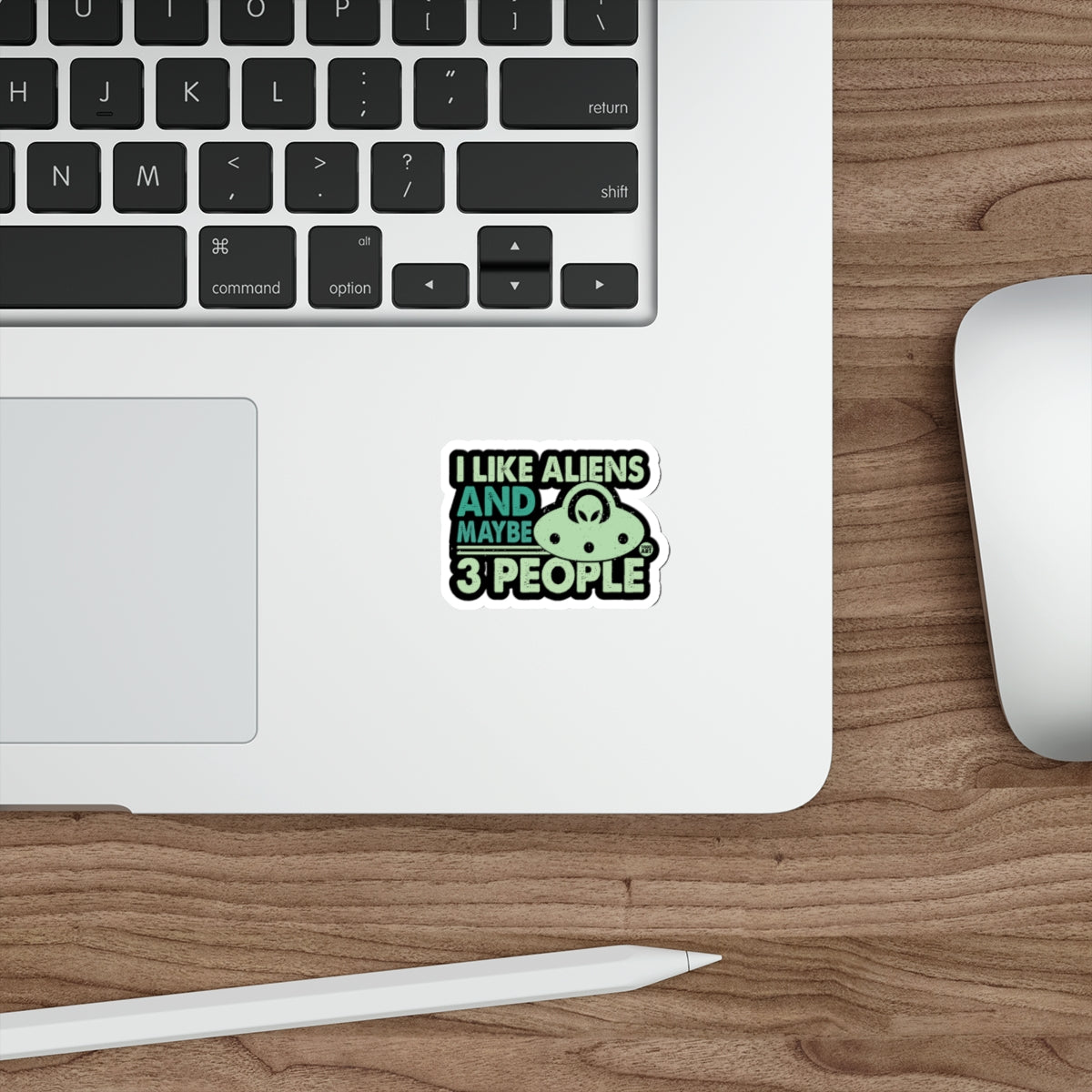Sticker on laptop: "I LIKE ALIENS AND MAYBE 3 PEOPLE" with alien and UFO graphic.